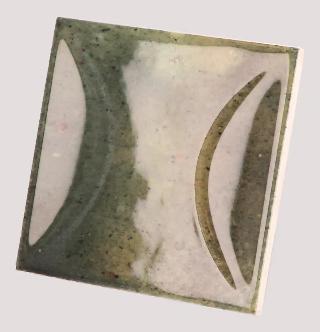 Hanoi Wandfliese in Wild Olive Glasur, Format 10x10 cm, schräge Studio Aufnahme mit sichtbarem Glasurglanz.