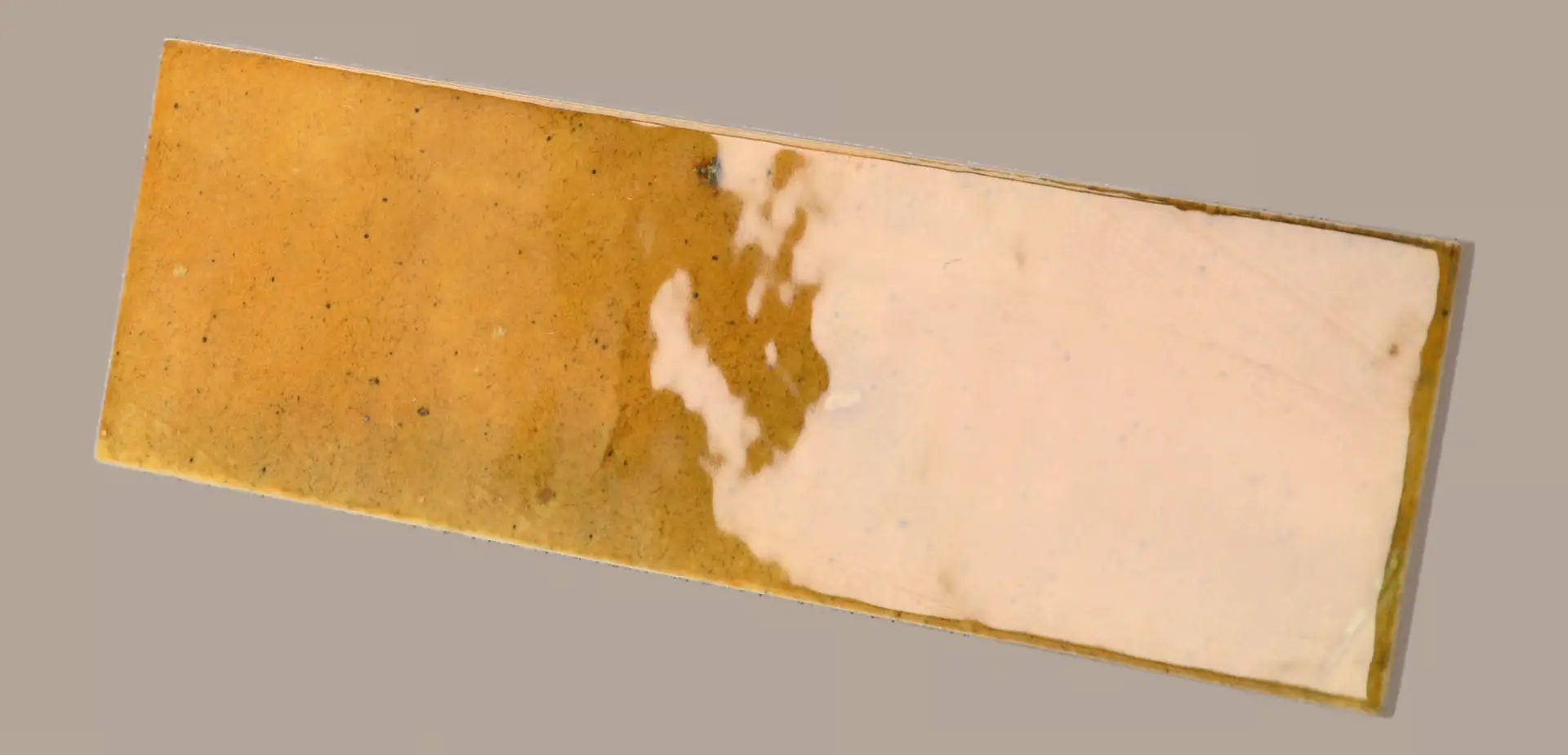 Hanoi Wandfliese in Caramel Glasur, Format 6,5x20 cm, schräge Studio Aufnahme mit sichtbarem Glasurglanz.
