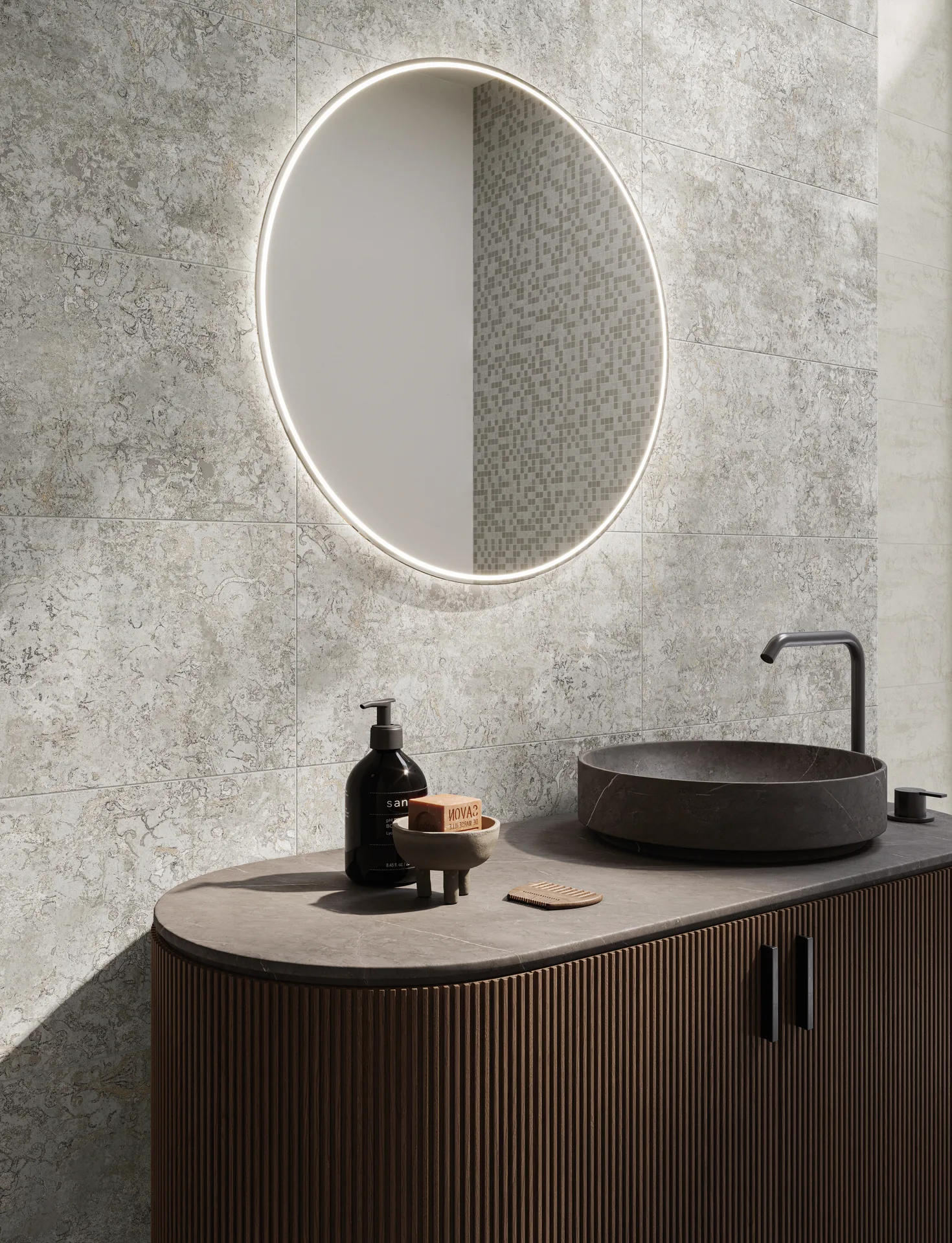 Waschplatz vor hell gemusterter Steinoptik-Wand mit Rundspiegel und Aufsatzbecken, Fliesenformat 30×60 cm.