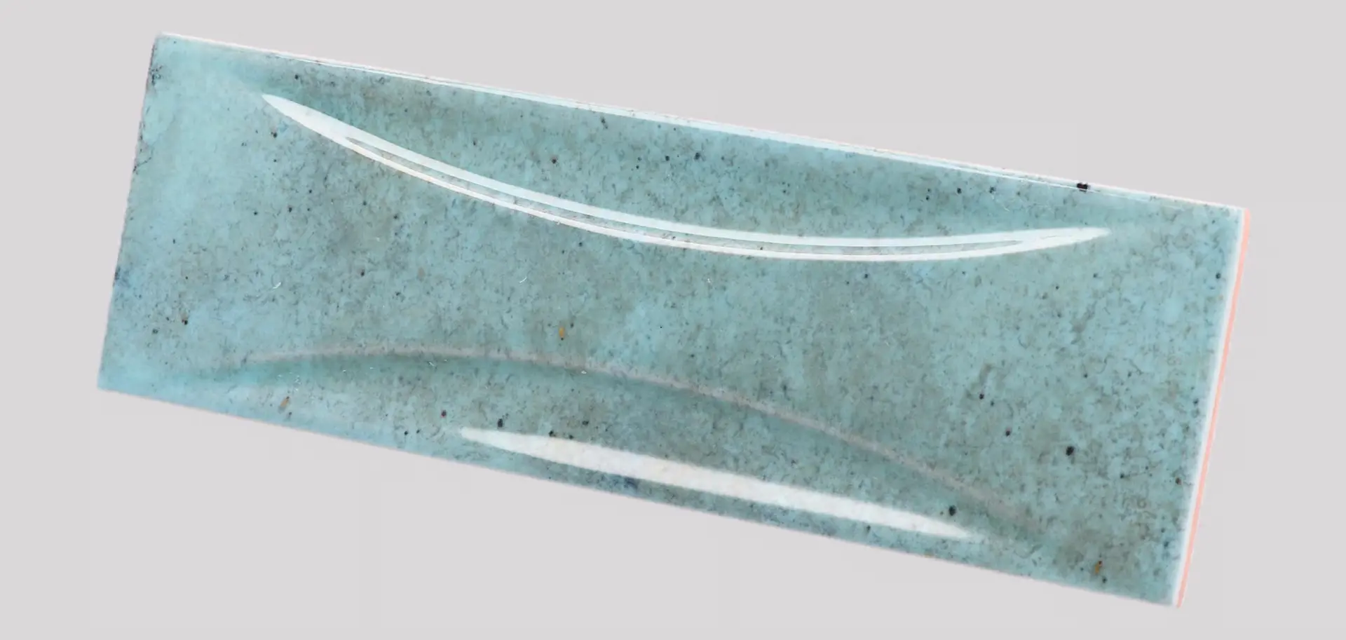 Hanoi Wandfliese in Sky Blue Glasur, Format 6,5x20 cm, schräge Studio Aufnahme mit sichtbarem Glasurglanz.