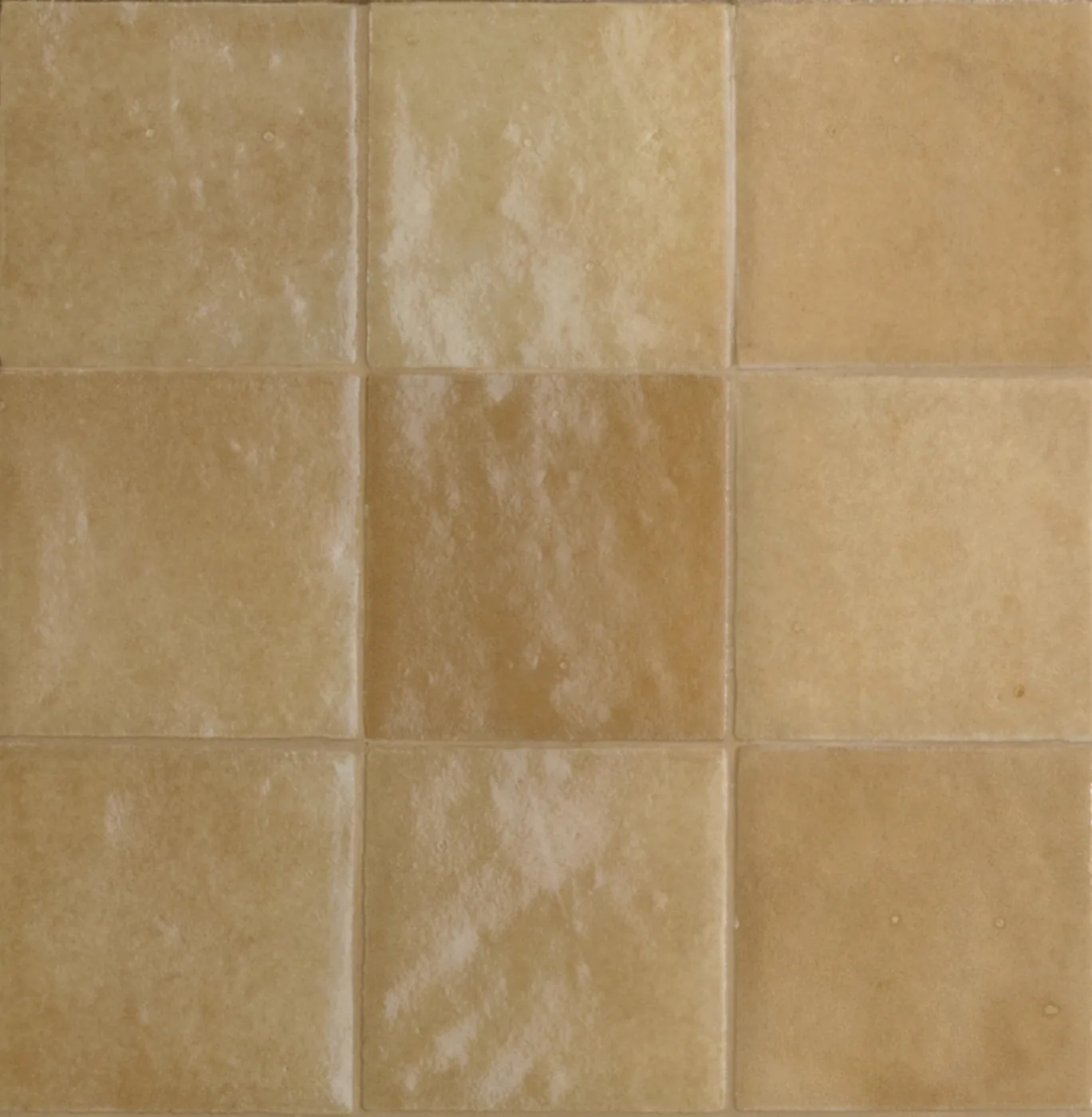 Glänzende Wandfliesen 10x10 cm in Ocker und Karamell, jede Fliese mit eigener Farbnuance und welliger Glasur