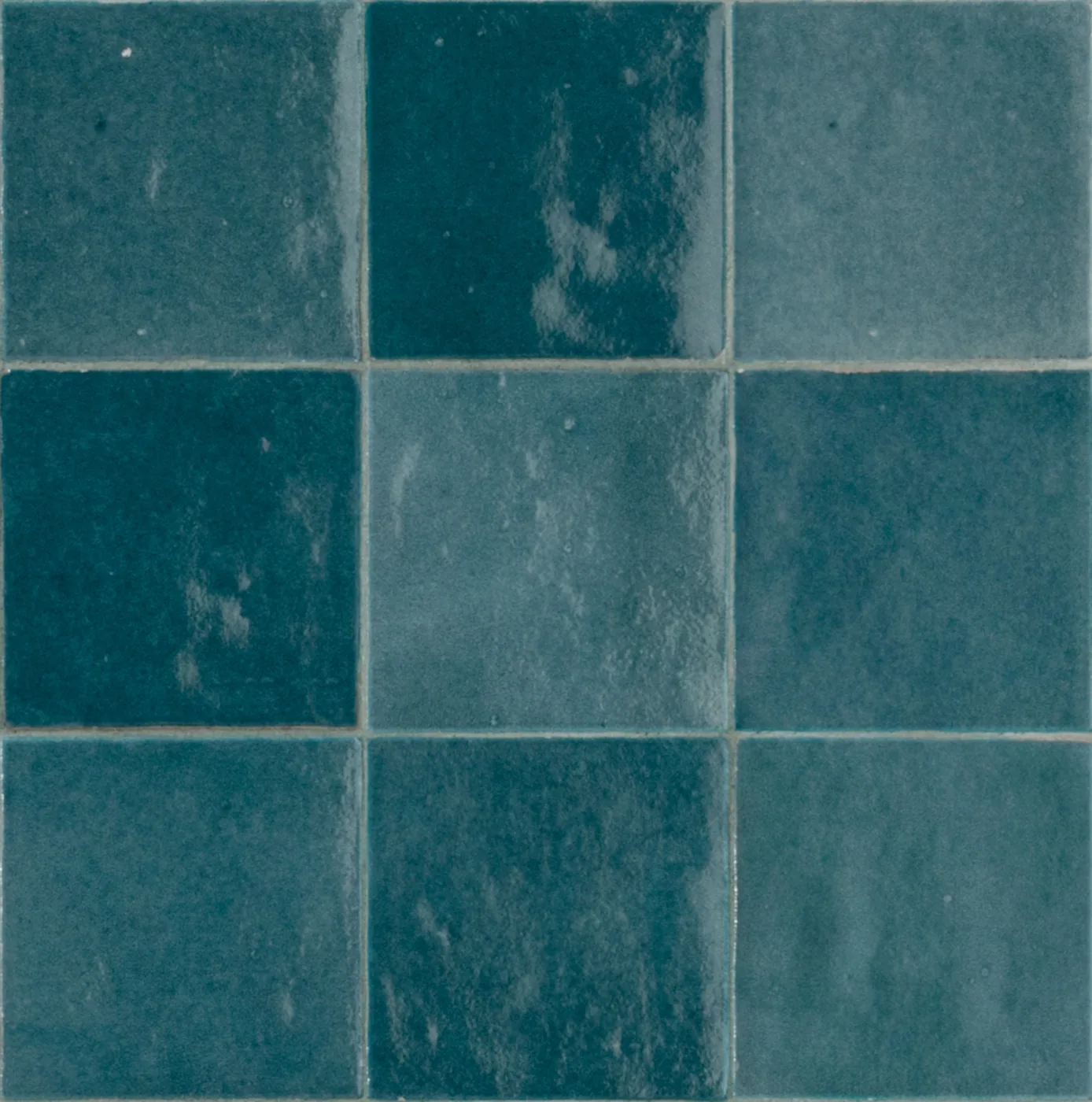Glänzende Wandfliesen 10x10 cm in tiefem Petrol mit Farbnuancen von Fliese zu Fliese und welliger Glasur