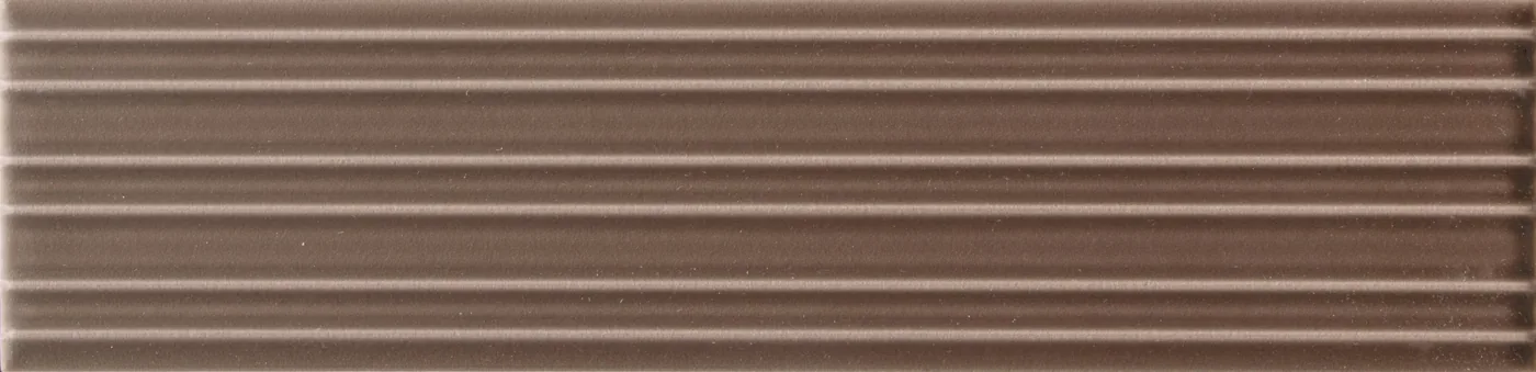 Rechteckige Wandfliese in dunklem Nussbraun, matt, mit parallelem Rillenrelief, im Format 6x24,6 cm.