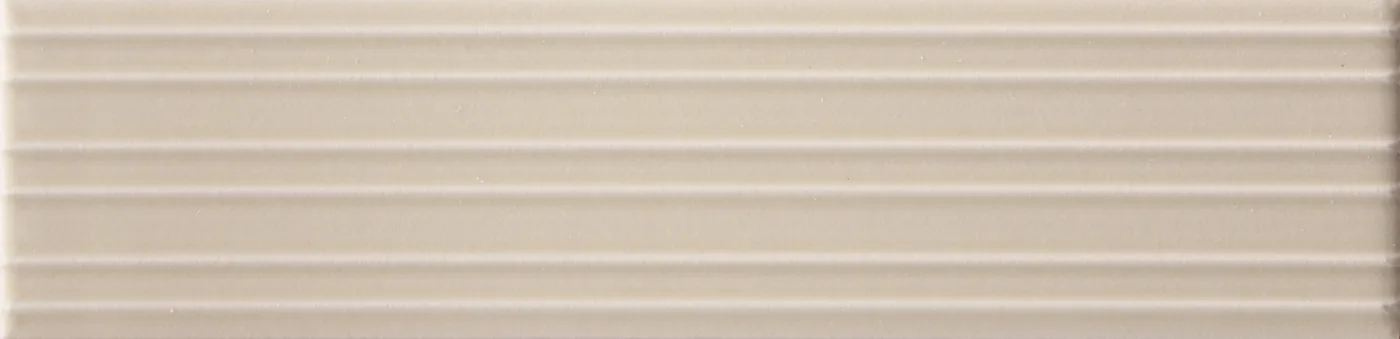 Rechteckige Wandfliese in hellem Greige-Taupe, matt, mit parallelem Rillenrelief, im Format 6x24,6 cm.