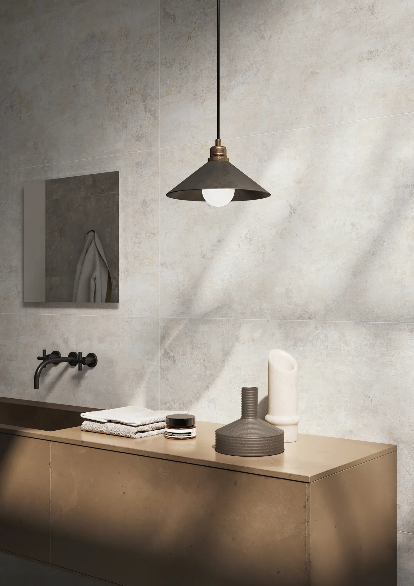 Waschplatz vor heller Steinoptik-Wand mit kupferfarbenem Unterschrank und Pendelleuchte, Fliesenformat 60×120 cm.