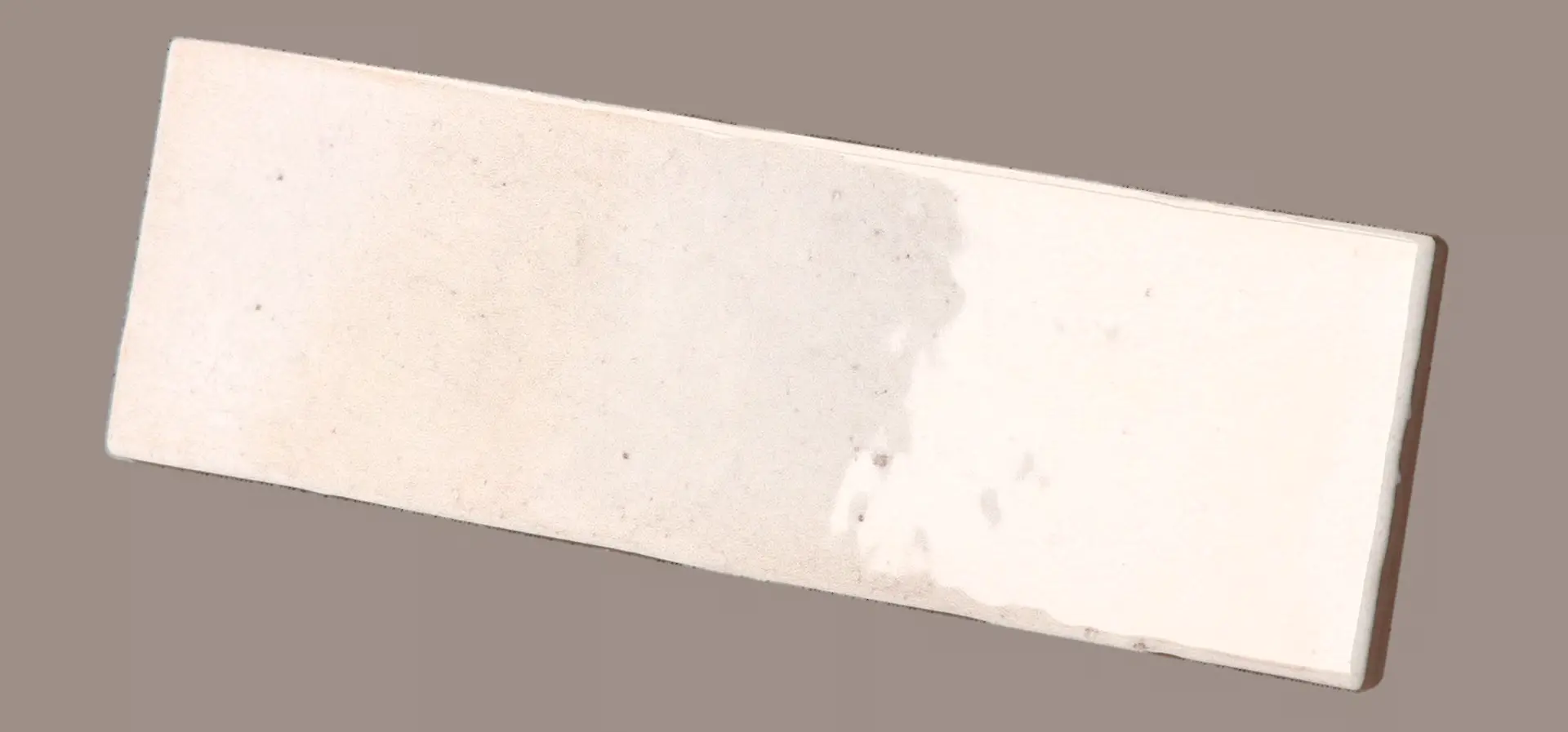 Hanoi Wandfliese in White Glasur, Format 5,1x16,1 cm, schräge Studio Aufnahme mit sichtbarem Glasurglanz.