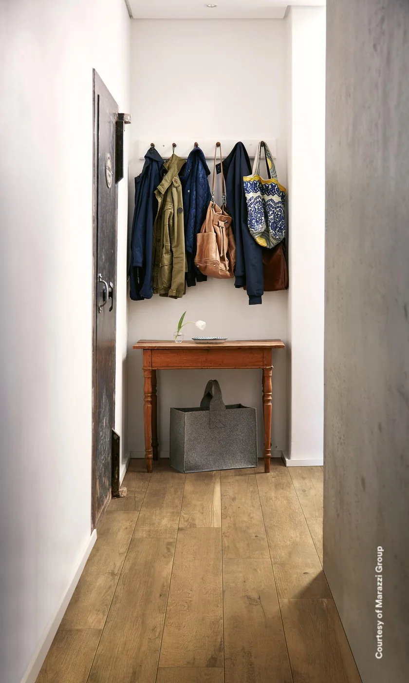 Treverkdear Natural 20x120 cm im schmalen Eingangsflur mit Garderobenhaken und altem Holztisch