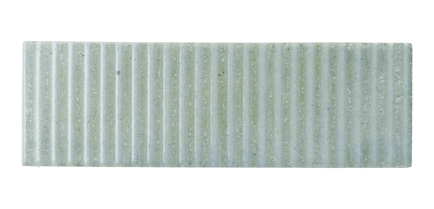Zart graugrüne matte Keramikfliese 6×18,6 cm mit vertikalem Rillenrelief und changierender, handgemachter Lasur.