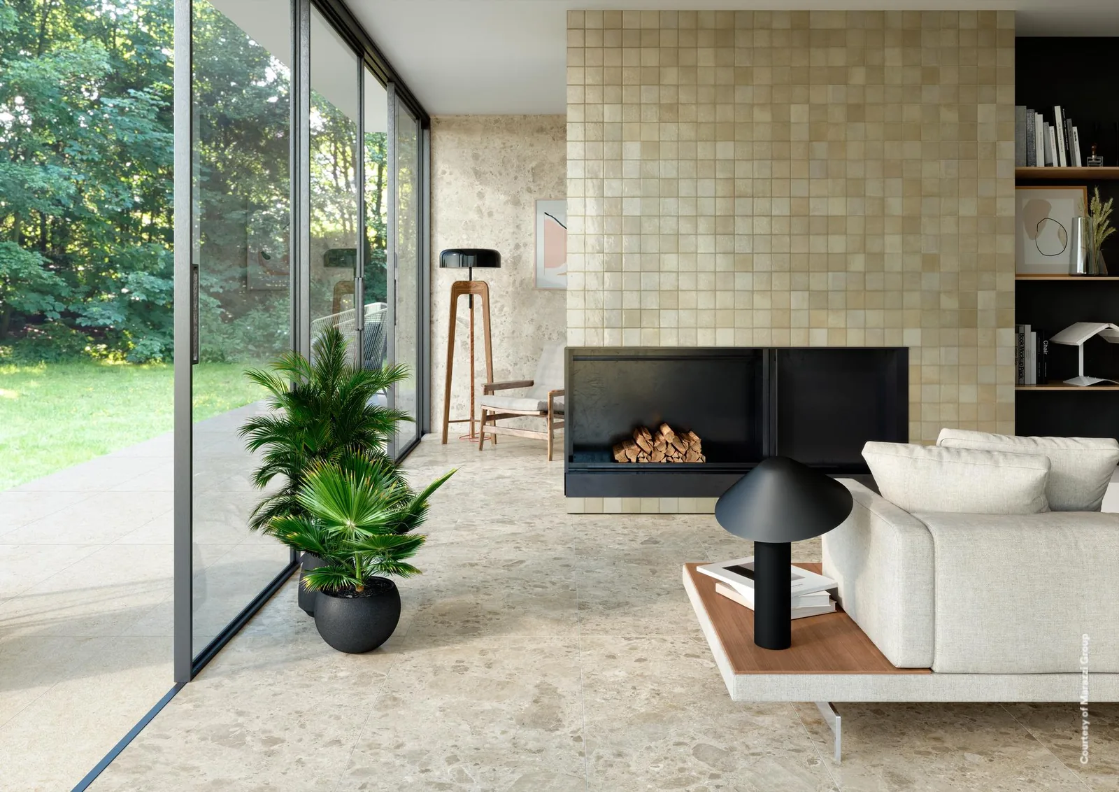 Wohnraum mit weißem Sofa, Kamin und Glasfront zum Garten, Boden in beiger Terrazzo-Optik mit grauen Einschlüssen.