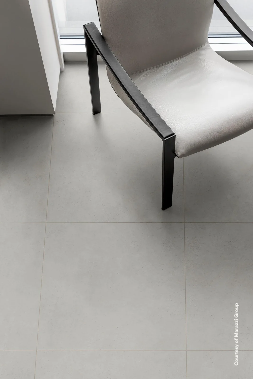 Wohnraum mit Boden aus Marazzi Work White 60x60 in Betonoptik, Sessel am Fenster