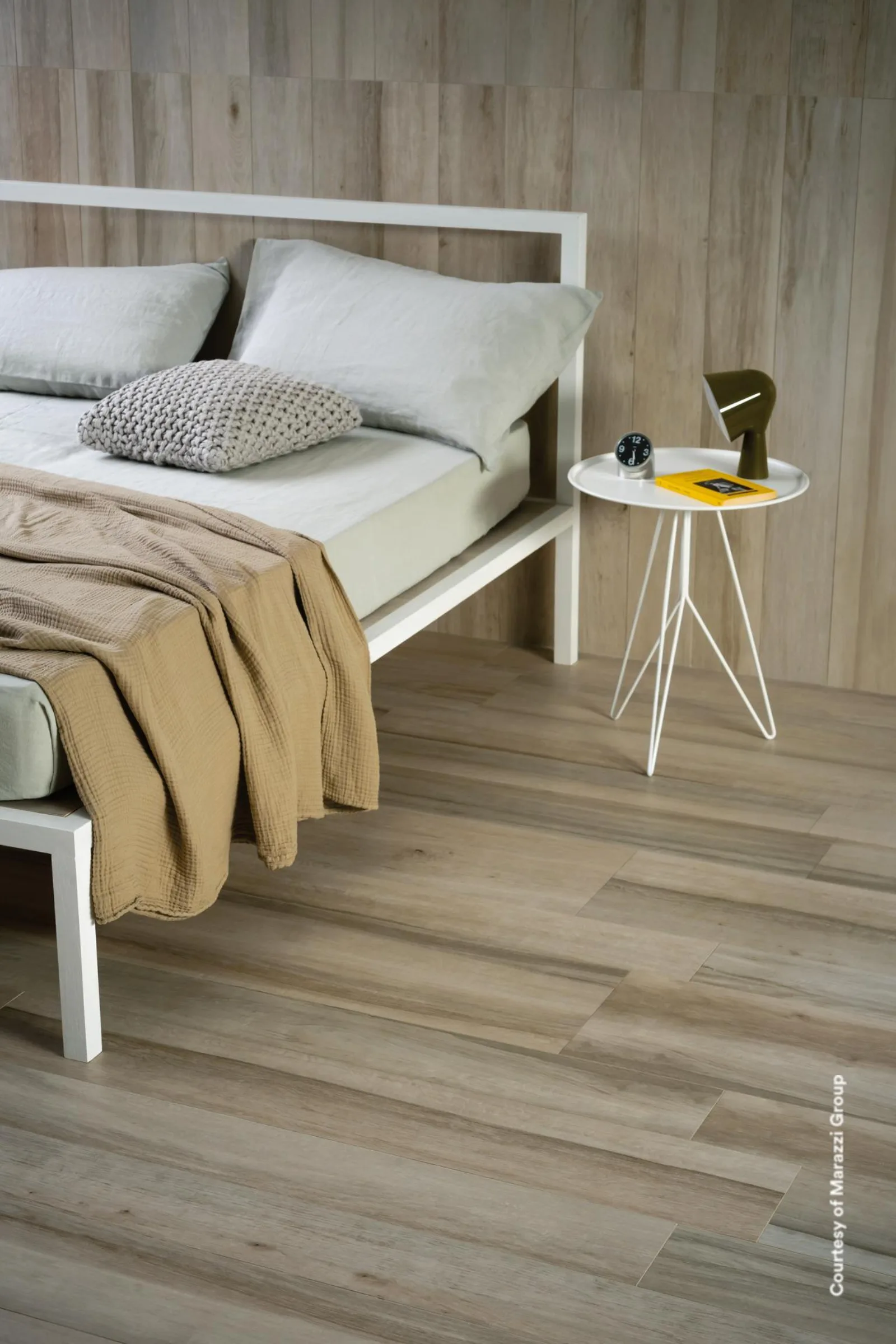 Schlafzimmer mit weißem Bett und Beistelltisch, Boden und Wand in heller, gekalkter Holzoptik Teak Asia.