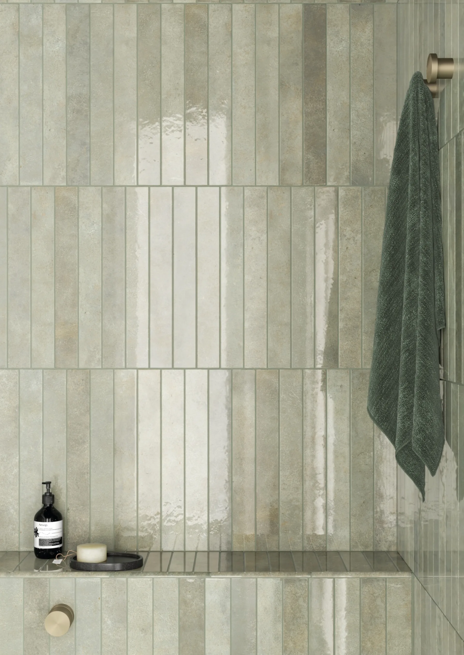 Dusche mit hellgrünen, senkrechten Riemchen, dunkelgrünem Handtuch am Haken und Seifenspender.