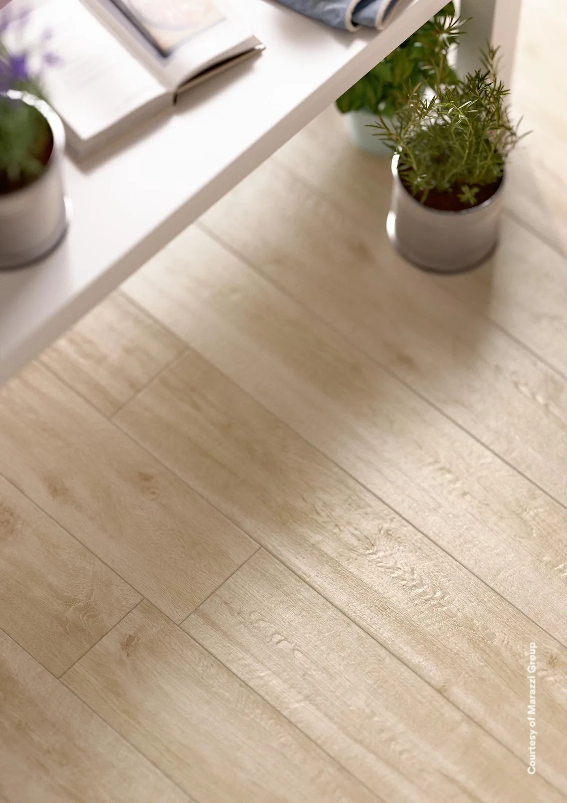 Weißer Tisch mit Kräutertöpfen über einem Boden aus hellen birkenbeigen Holzoptik-Dielen