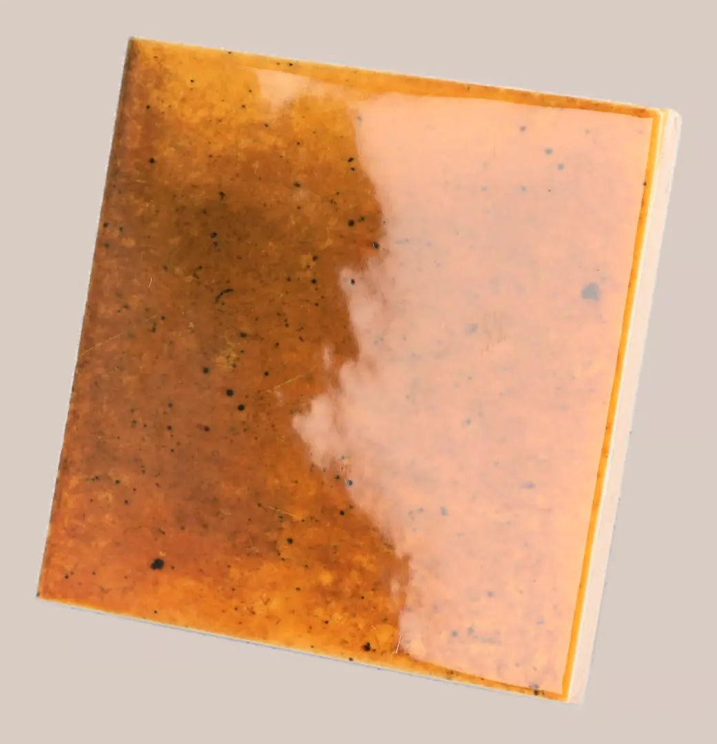 Hanoi Wandfliese in Burnt Red Glasur, Format 10x10 cm, schräge Studio Aufnahme mit sichtbarem Glasurglanz.