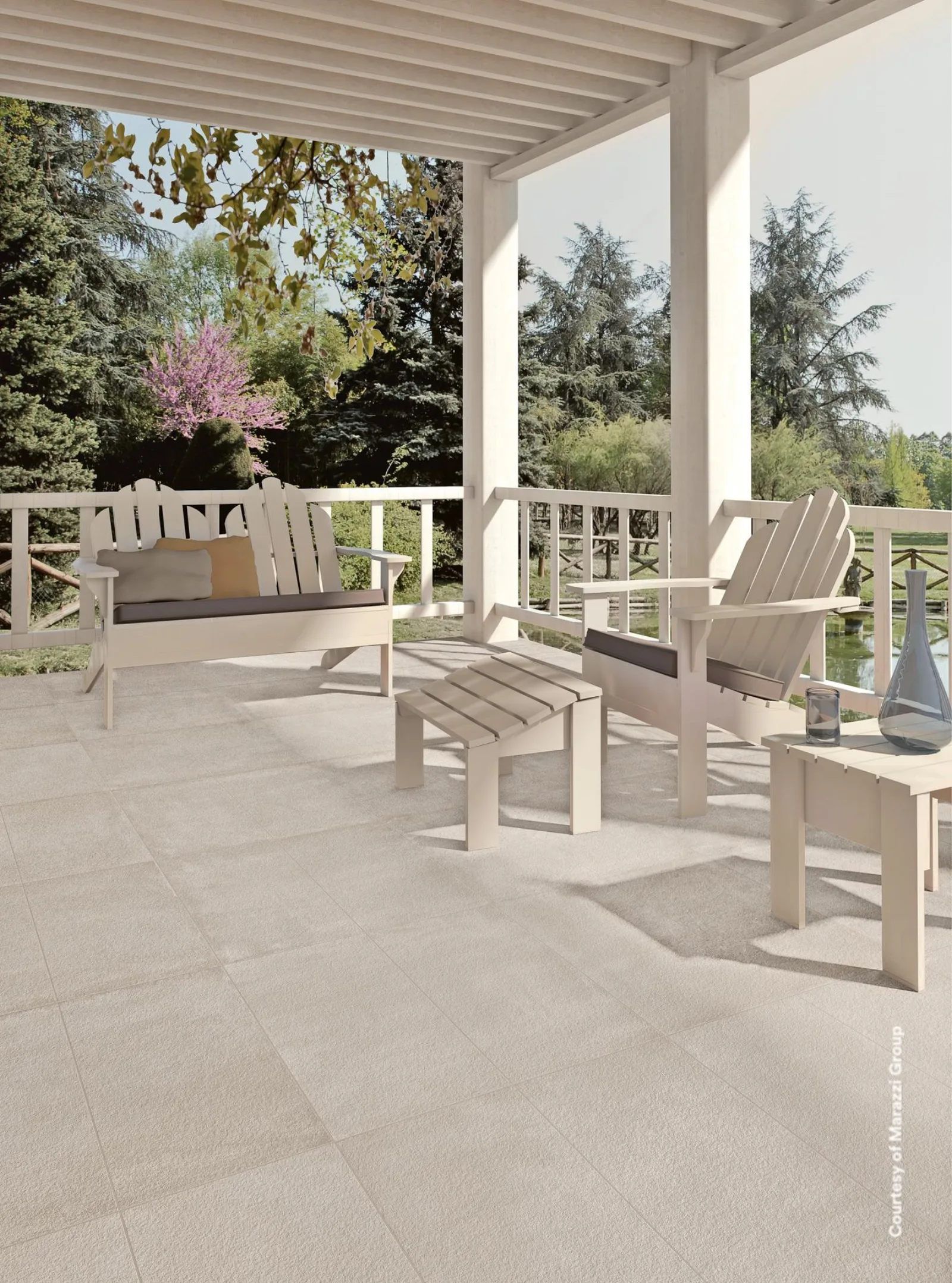 Überdachte Terrasse mit hellen Holzmöbeln, großformatiger Bodenbelag und Blick in den Garten.