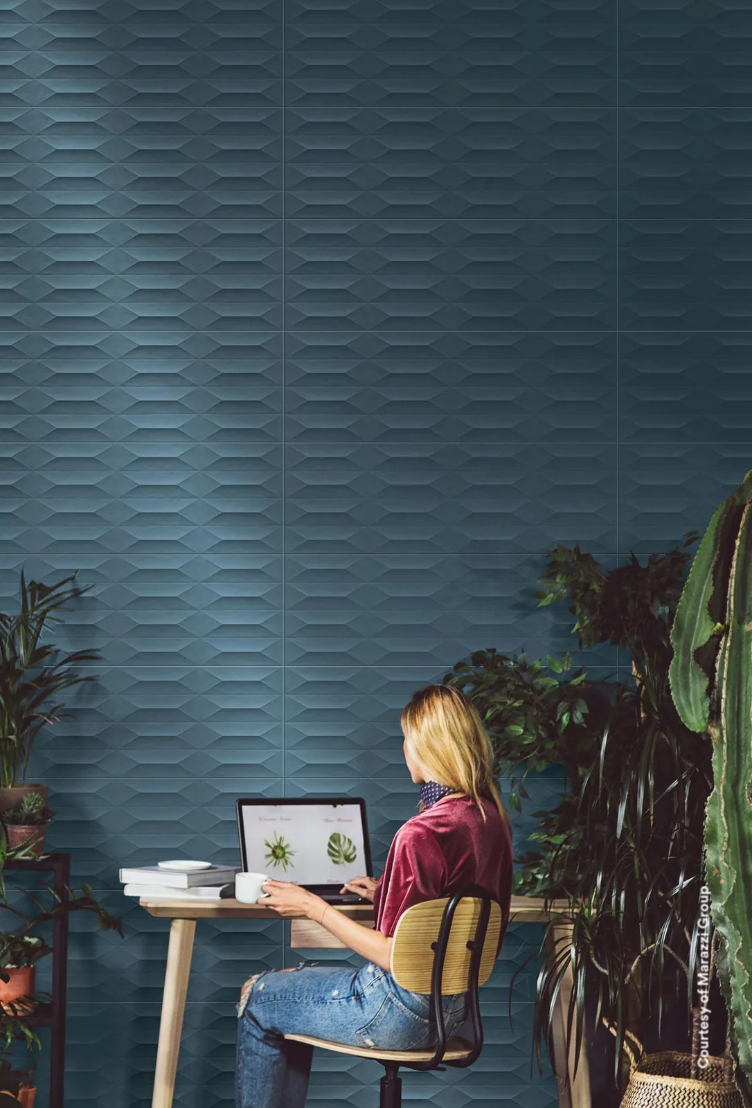 Arbeitsplatz mit Schreibtisch vor einer Wand aus dunkelblauen Reliefwandfliesen 30x90 cm mit Rautenstruktur