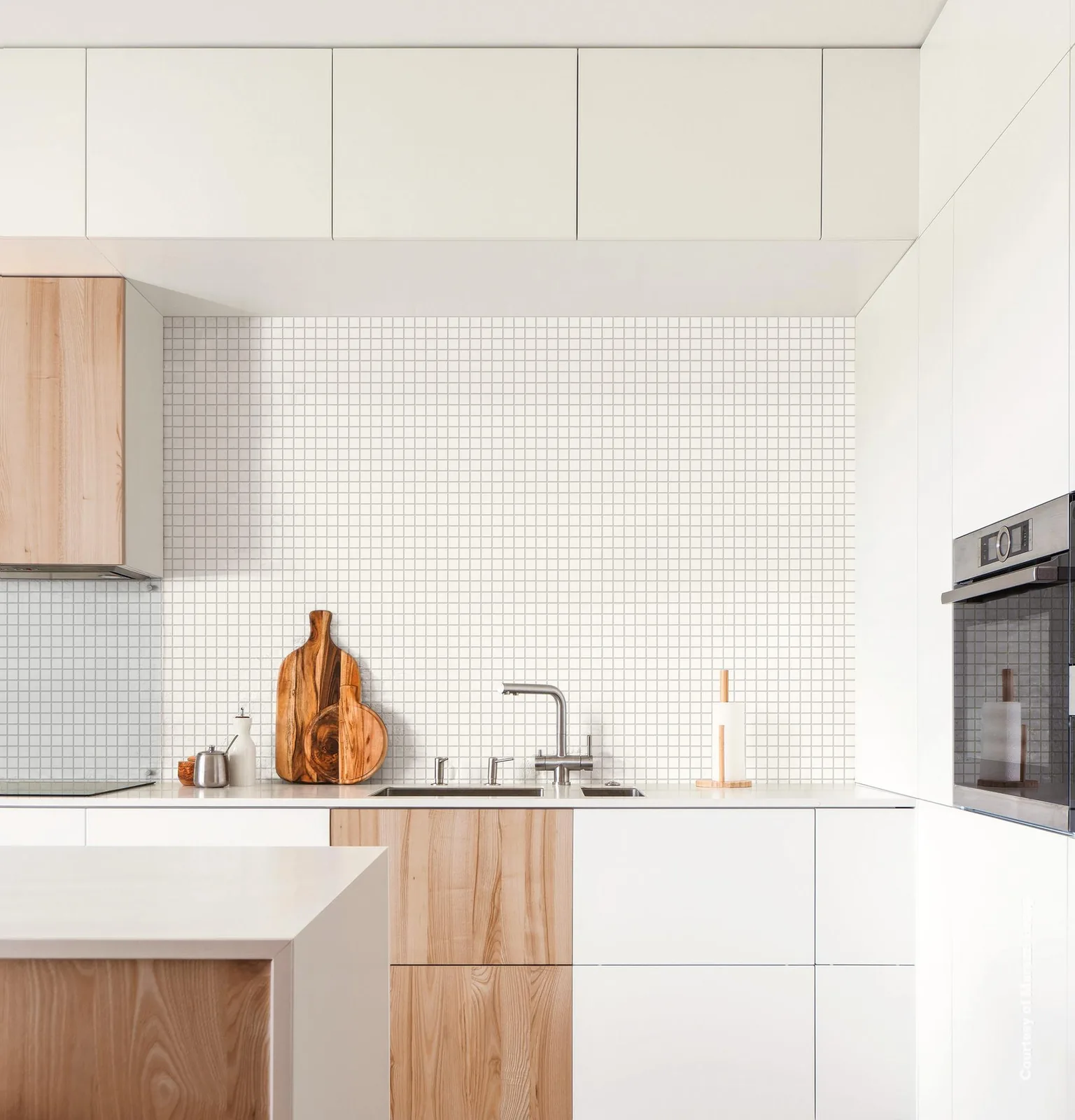 Helle Küche mit Rückwand aus kleinem weißem Mosaik mit grauen Fugen über Arbeitsplatte und Spüle