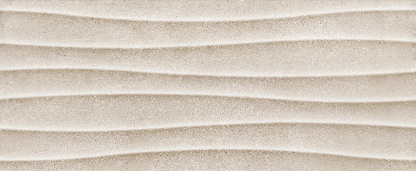 Graubeige Wandfliese 20×50 cm mit waagerechten Wellenrillen, die über die gesamte Fläche verlaufen.