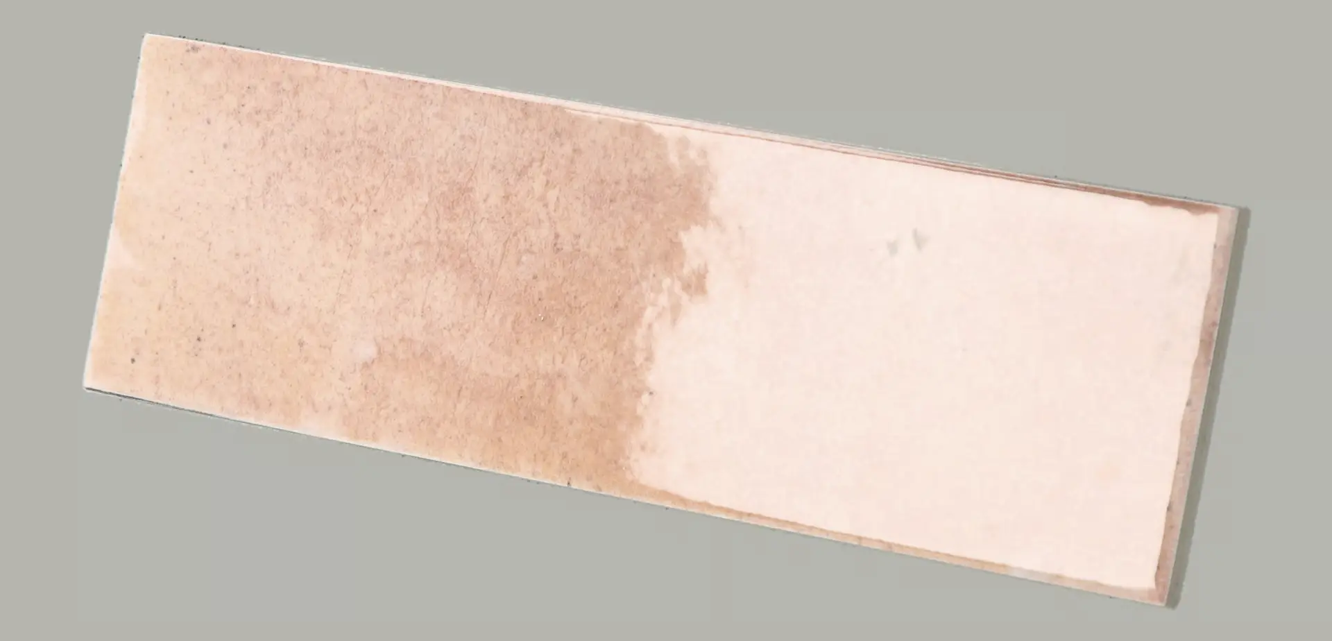 Hanoi Wandfliese in Pink Glasur, Format 6,5x20 cm, schräge Studio Aufnahme mit sichtbarem Glasurglanz.