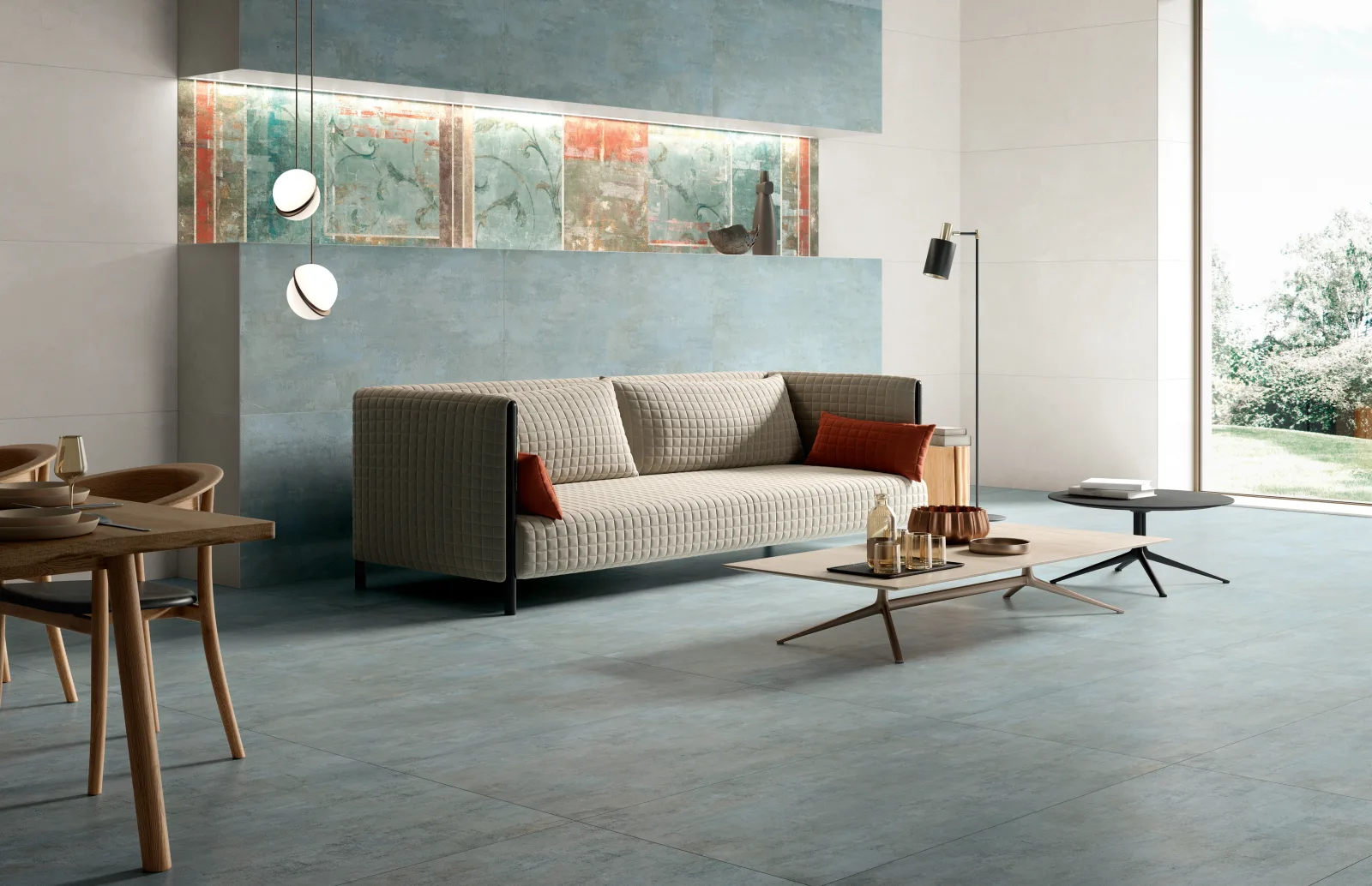 Wohnraum mit Sofa, graublauem Boden und Fresko-Wandband, Naxos Pictura Aquileia 60x120 cm.