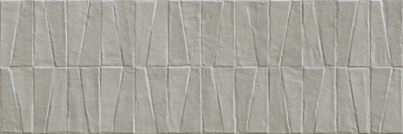 Mittelgraue Wandfliese 40×120 cm mit dreidimensionalem Relief aus versetzten Trapezen in matter Betonoptik