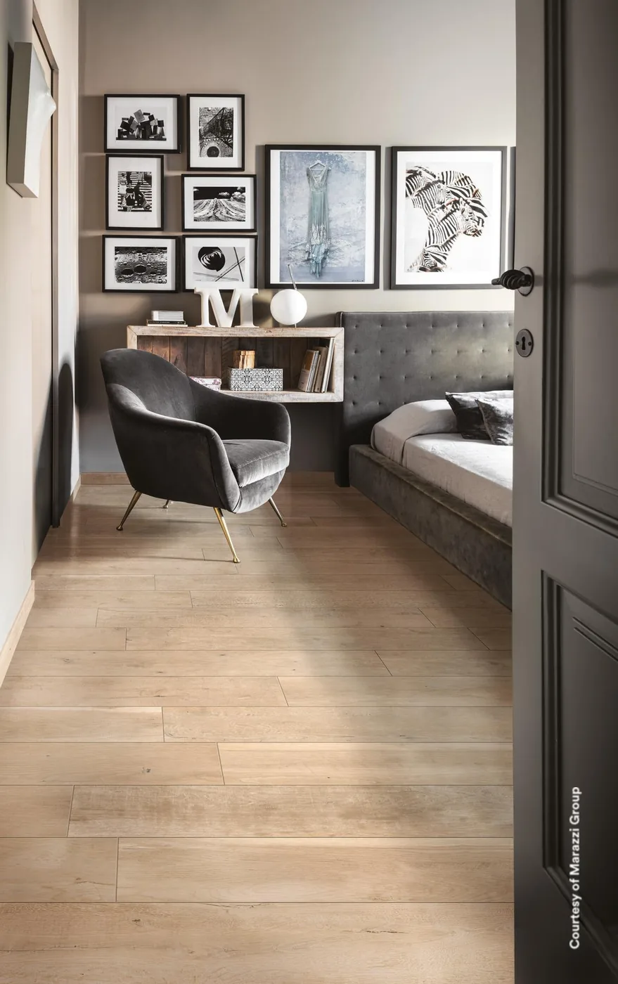 Treverkdear Beige 20x120 cm als heller Dielenboden im Schlafzimmer mit Sessel und Bilderwand