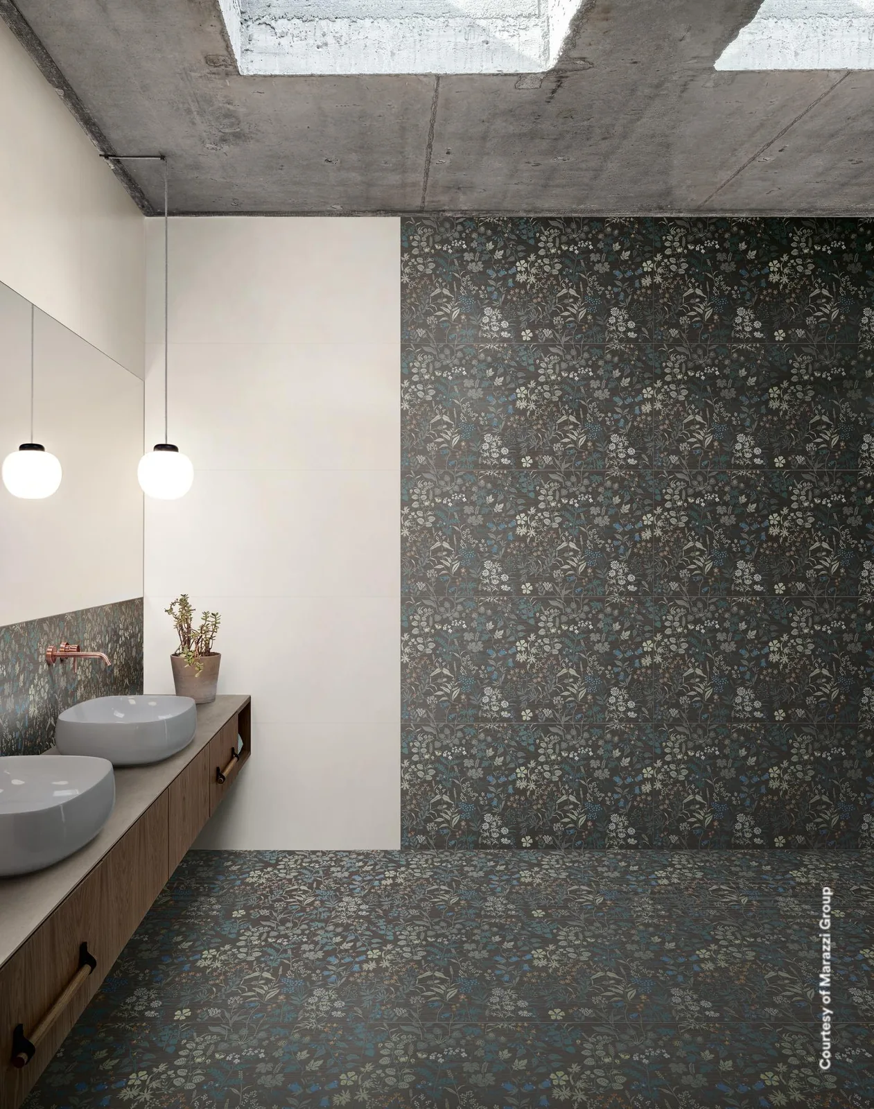 Bad mit dunklem Wiesenblumendekor an Wand und Boden, daneben eine helle Beigewand und ein Holzwaschtisch mit zwei Becken.