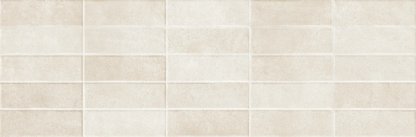 Sandfarbene Wandfliese 25×76 cm mit reliefartigem Raster aus versetzten, leicht erhabenen Rechtecken.