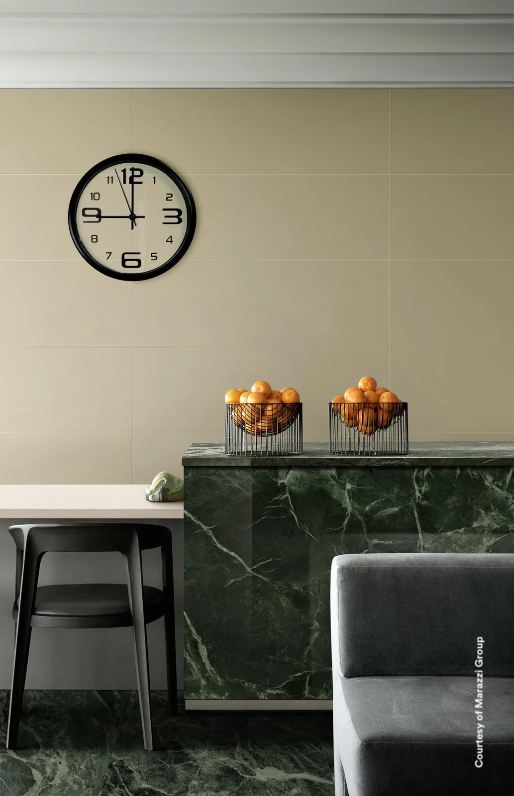 Essbereich mit Theke aus grünem Marmor vor einer glatten elfenbeinfarbenen Fliesenwand mit runder Wanduhr.