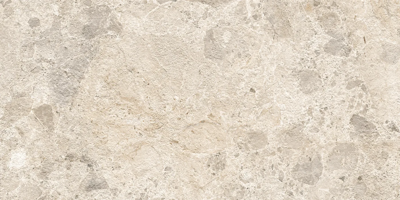 Beige Fliese 30×60 cm in Terrazzo-Optik mit grauen und hellen Steinsplittern unterschiedlicher Größe auf heller Fläche.
