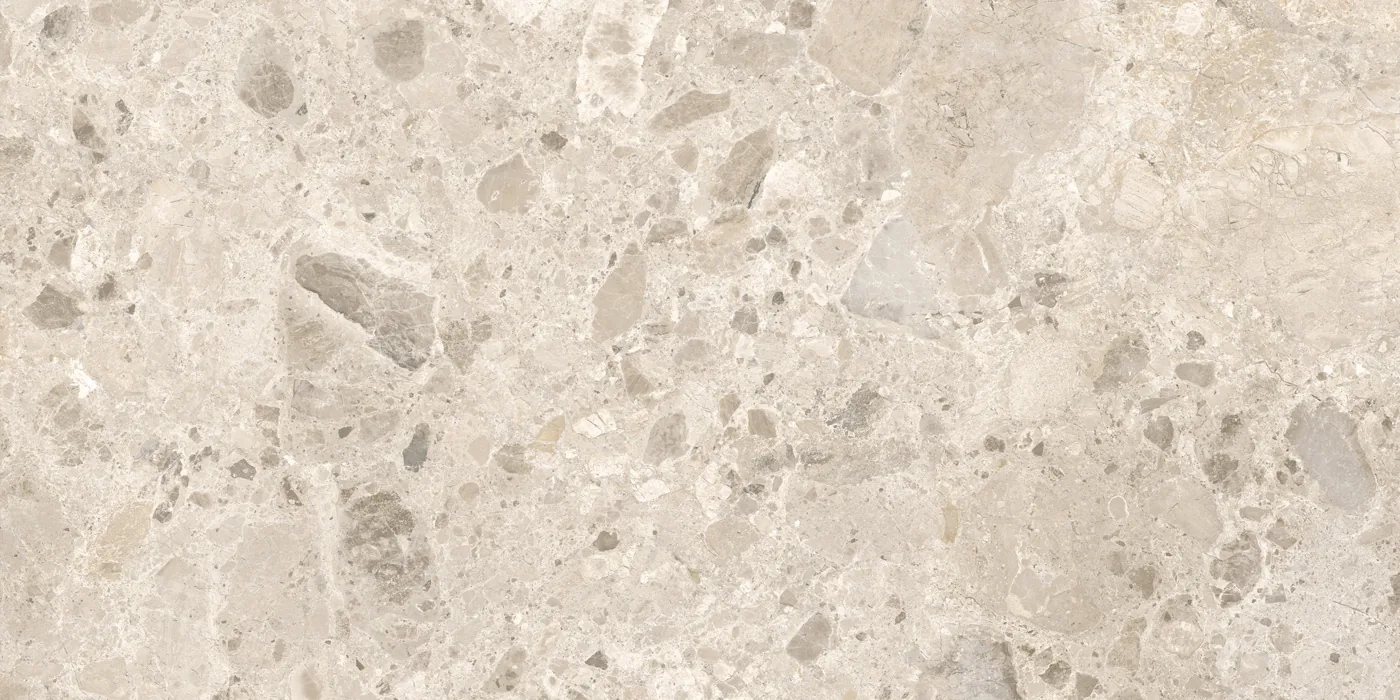 Beige Fliese 60×120 cm in Terrazzo-Optik mit grauen und hellen Steinsplittern unterschiedlicher Größe auf heller Fläche.