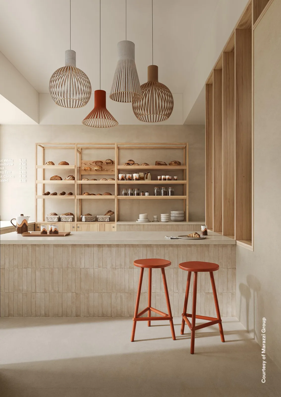 Küche mit Holzregalen, Brottheke, Pendelleuchten und roten Barhockern, Boden und Wände in hellem Sandbeige.