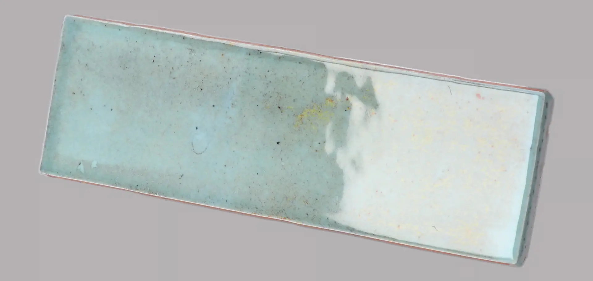 Hanoi Wandfliese in Sky Blue Glasur, Format 5,1x16,1 cm, schräge Studio Aufnahme mit sichtbarem Glasurglanz.