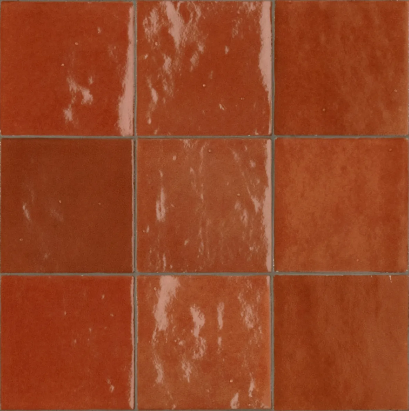 Glänzende Wandfliesen 10x10 cm in Ziegelrot mit orangen Nuancen und welliger, stark spiegelnder Glasur