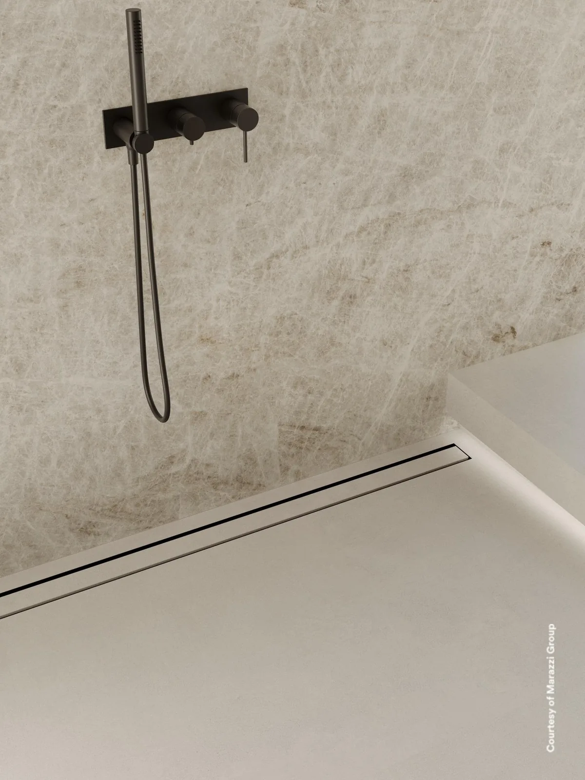 Dusche mit großformatiger hell graubeiger Marmoroptik an der Wand, schwarzer Armatur und bodengleicher Rinne.