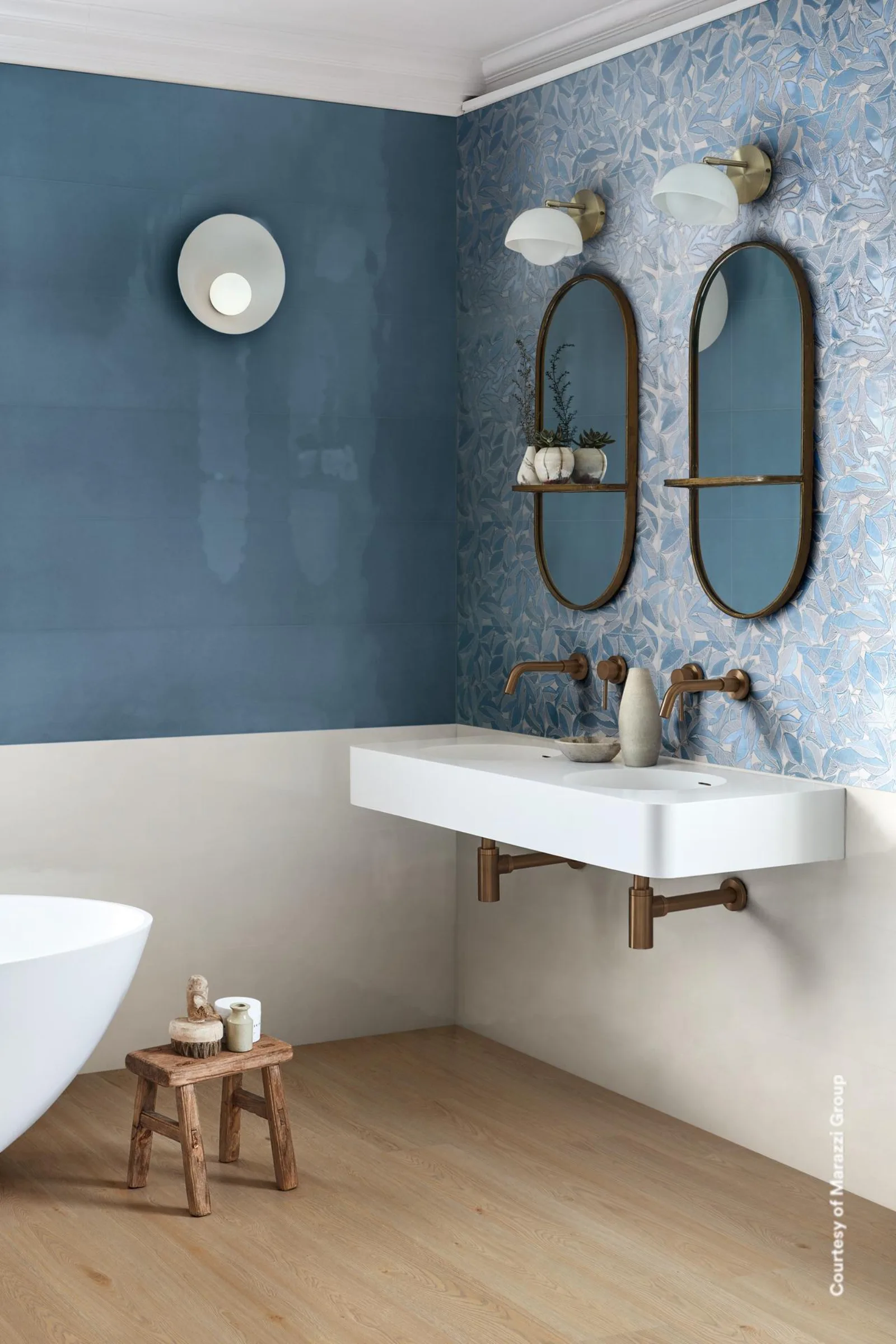Marazzi Bliss Decoro Leafy Freddo: Bad über Eck mit blauer Wandfläche, Blattdekor, ovalen Spiegeln und Wandwaschtisch