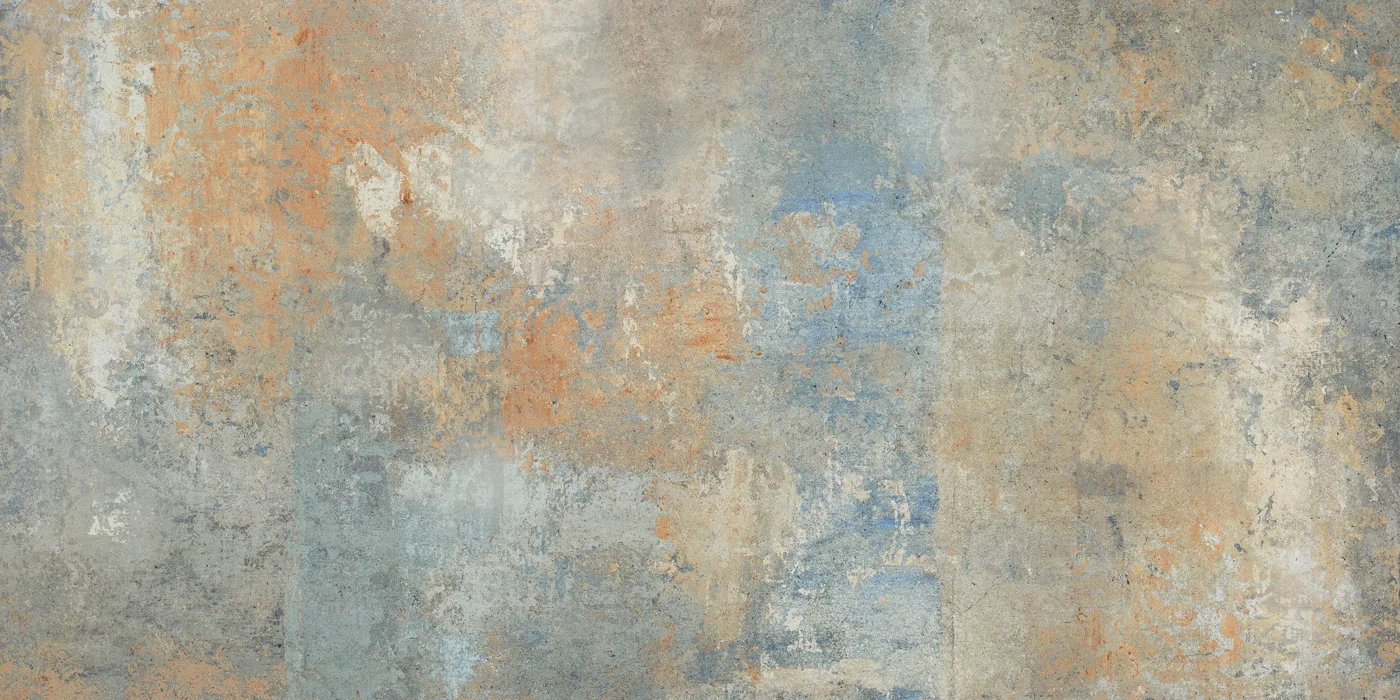 Wand- und Bodenfliese 60×120 cm mit verwittertem graubeigem Grund und blauen wie orangen Farbspuren, seidenmatte Oberfläche.