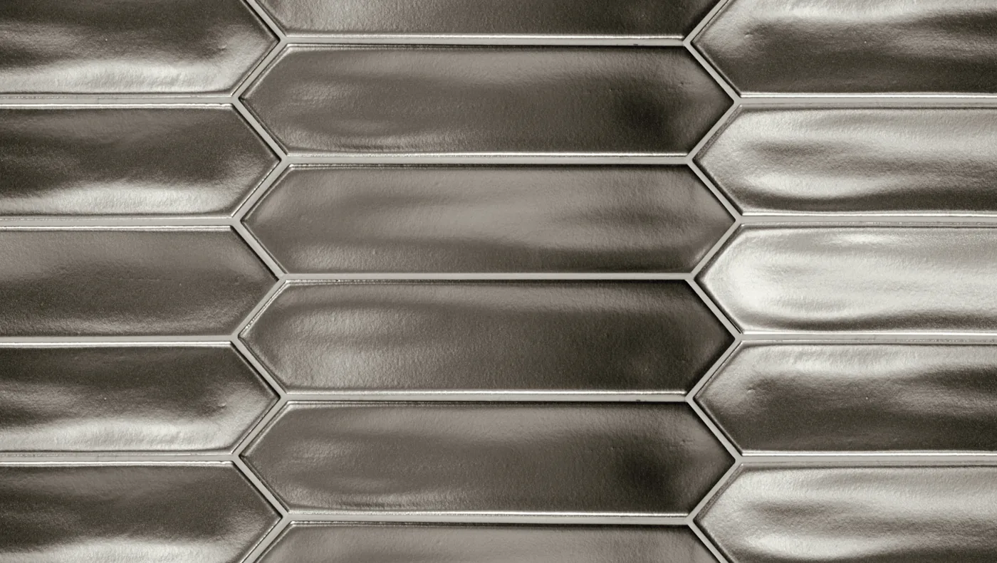 Silbergraue, spitz zulaufende Wandfliese 5×25 cm, glänzend metallisch glasiert mit changierenden Reflexen.