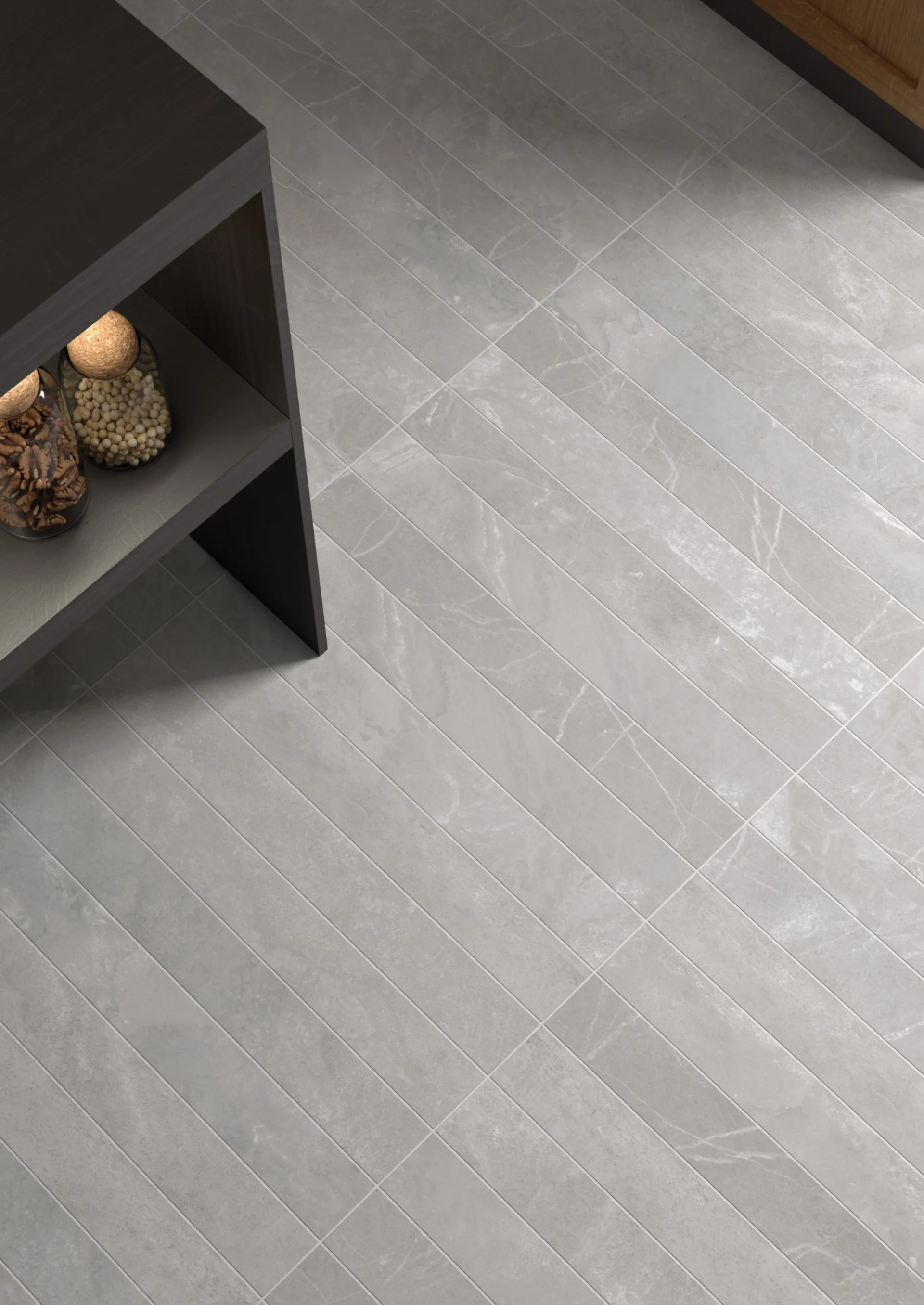 Equipe Marmoris Grey als Boden: hellgraue Marmor-Riemchen diagonal verlegt neben dunklem Sideboard.