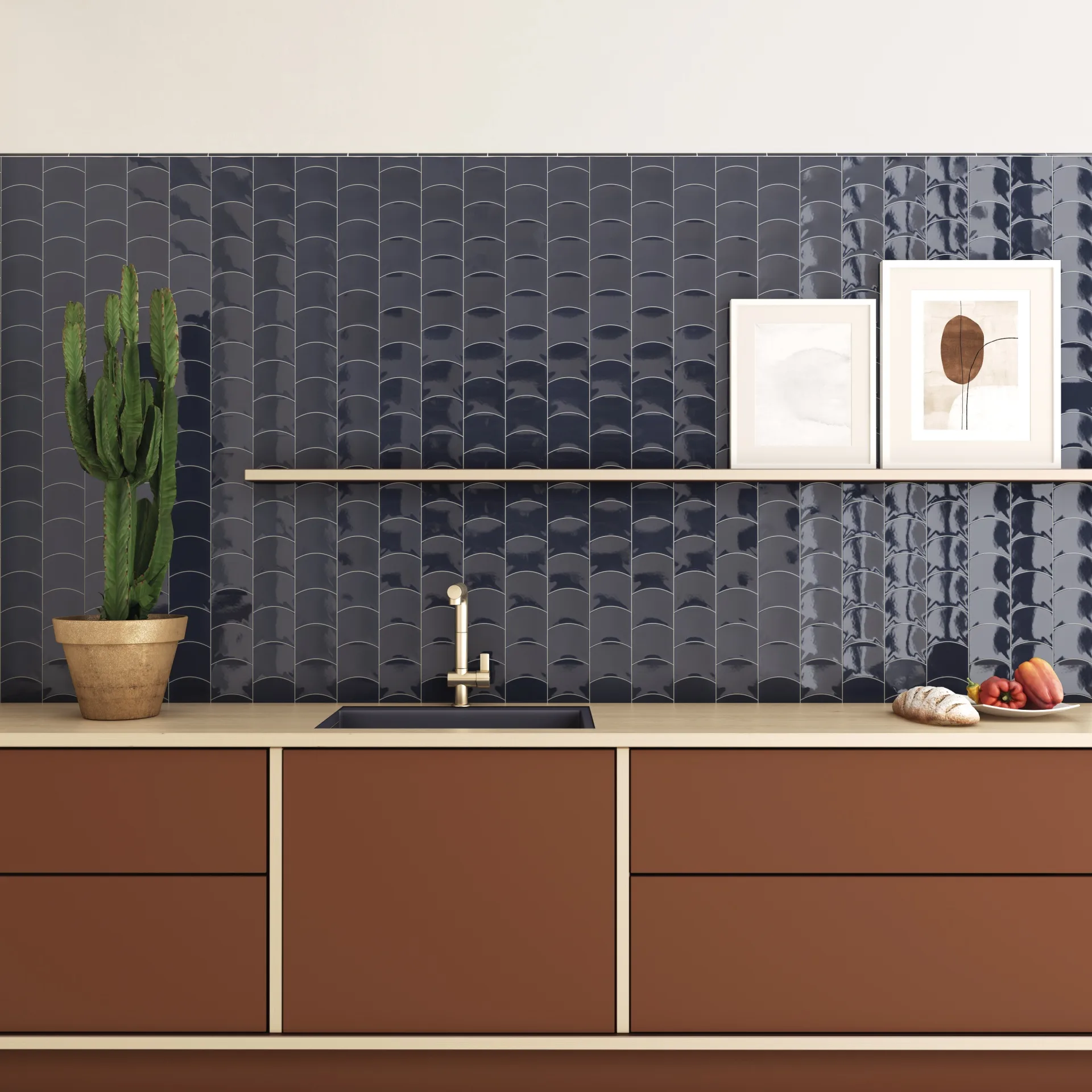 Küche mit dunkelblauer Wellenfliesenwand, terrakottafarbenen Fronten, Messingarmatur und Bildern.