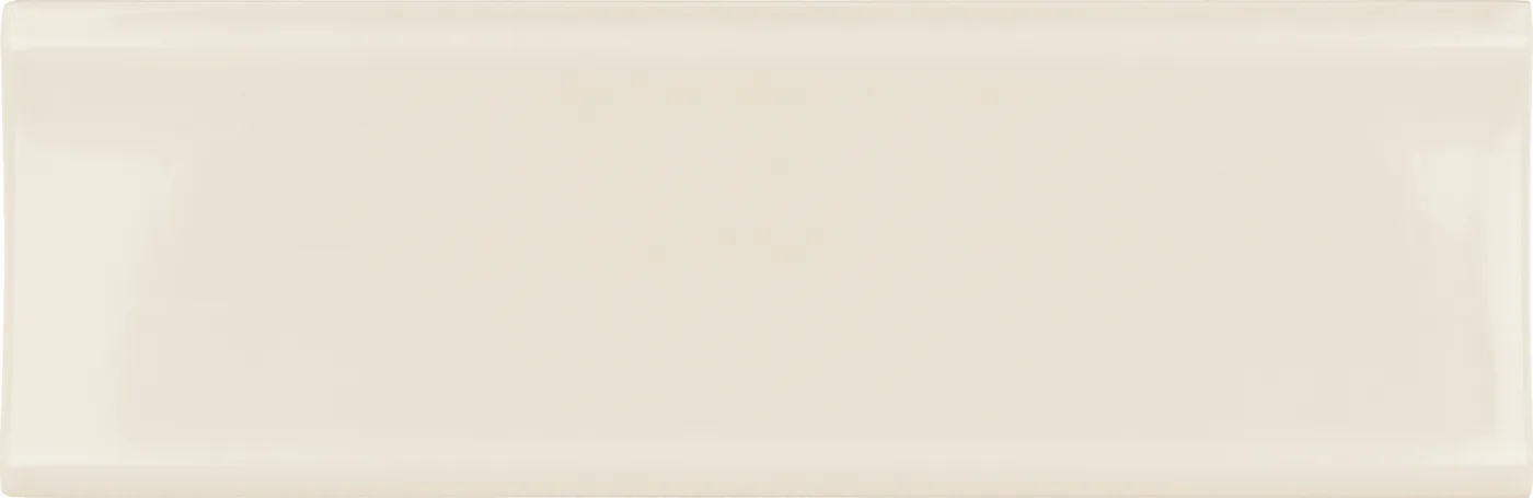 Konkav gewölbte Wandfliese 6,5×20 cm in warmem Cremebeige, glänzend glasiert, frontal freigestellt vor weißem Grund.
