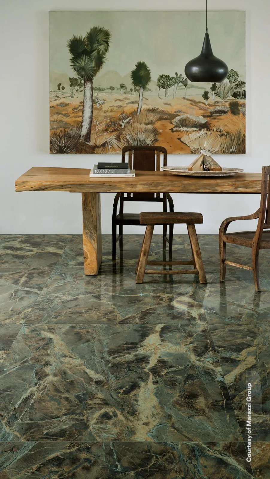 Arbeitsecke mit Holztisch und Gemälde, darunter ein glänzender Boden in graugrüner Marmoroptik mit goldenen Adern.