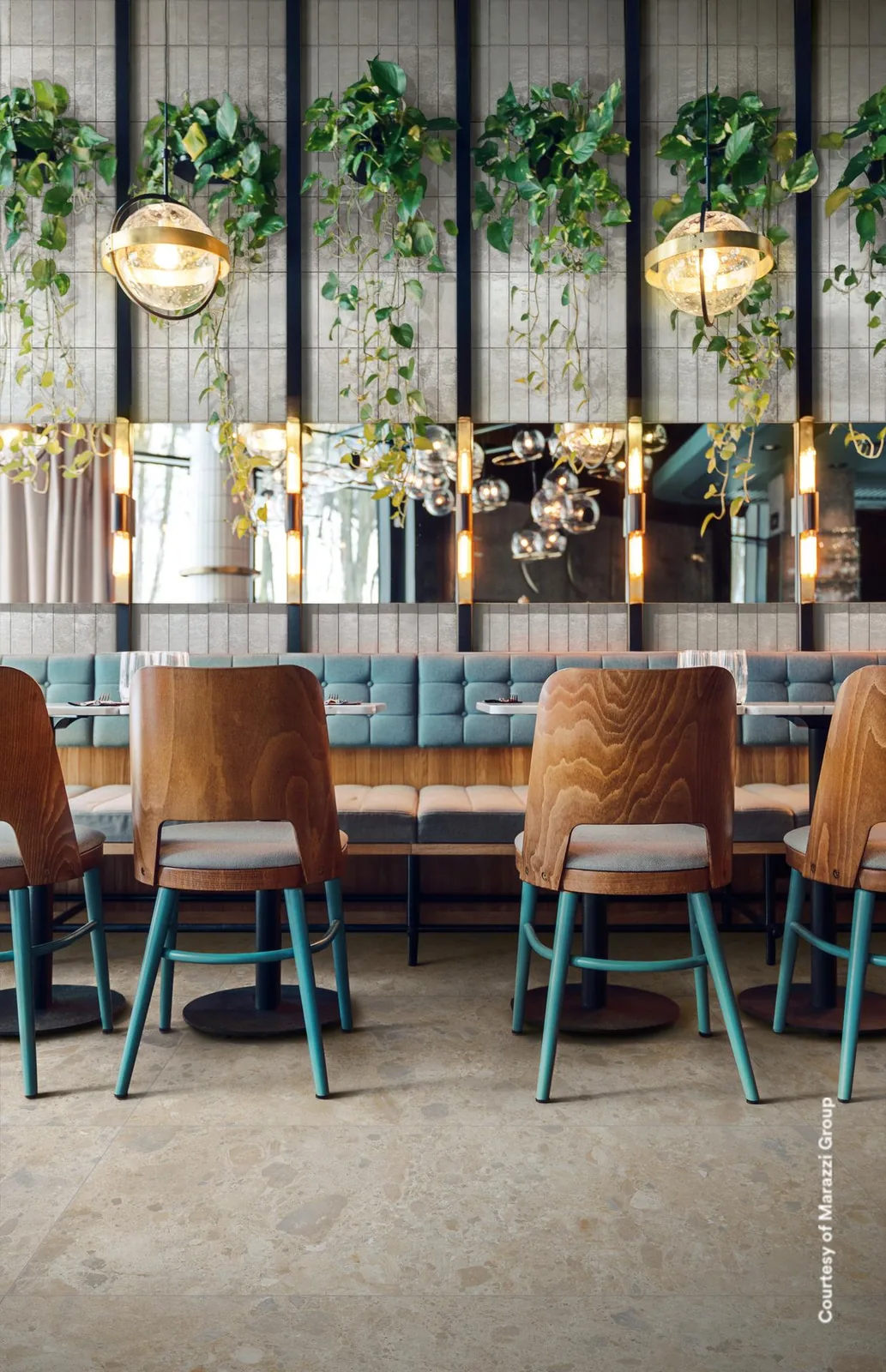 Restaurant mit Holzstühlen und Hängepflanzen, Boden in heller Terrazzo-Optik mit beigen und grauen Einschlüssen.