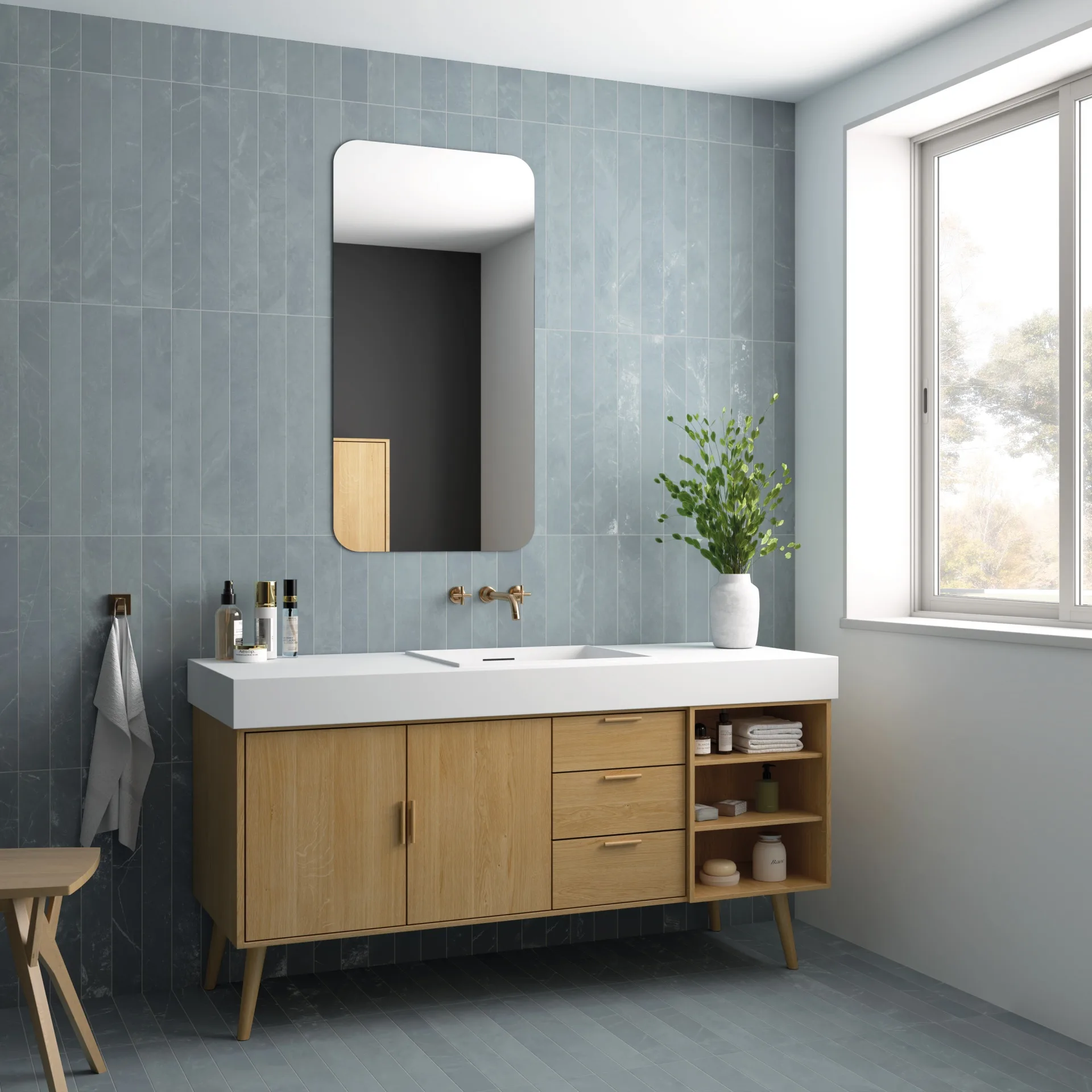 Equipe Marmoris Blue als Badwand: blaugraue Riemchen hinter Holz-Waschtisch mit Spiegel und Pflanze.