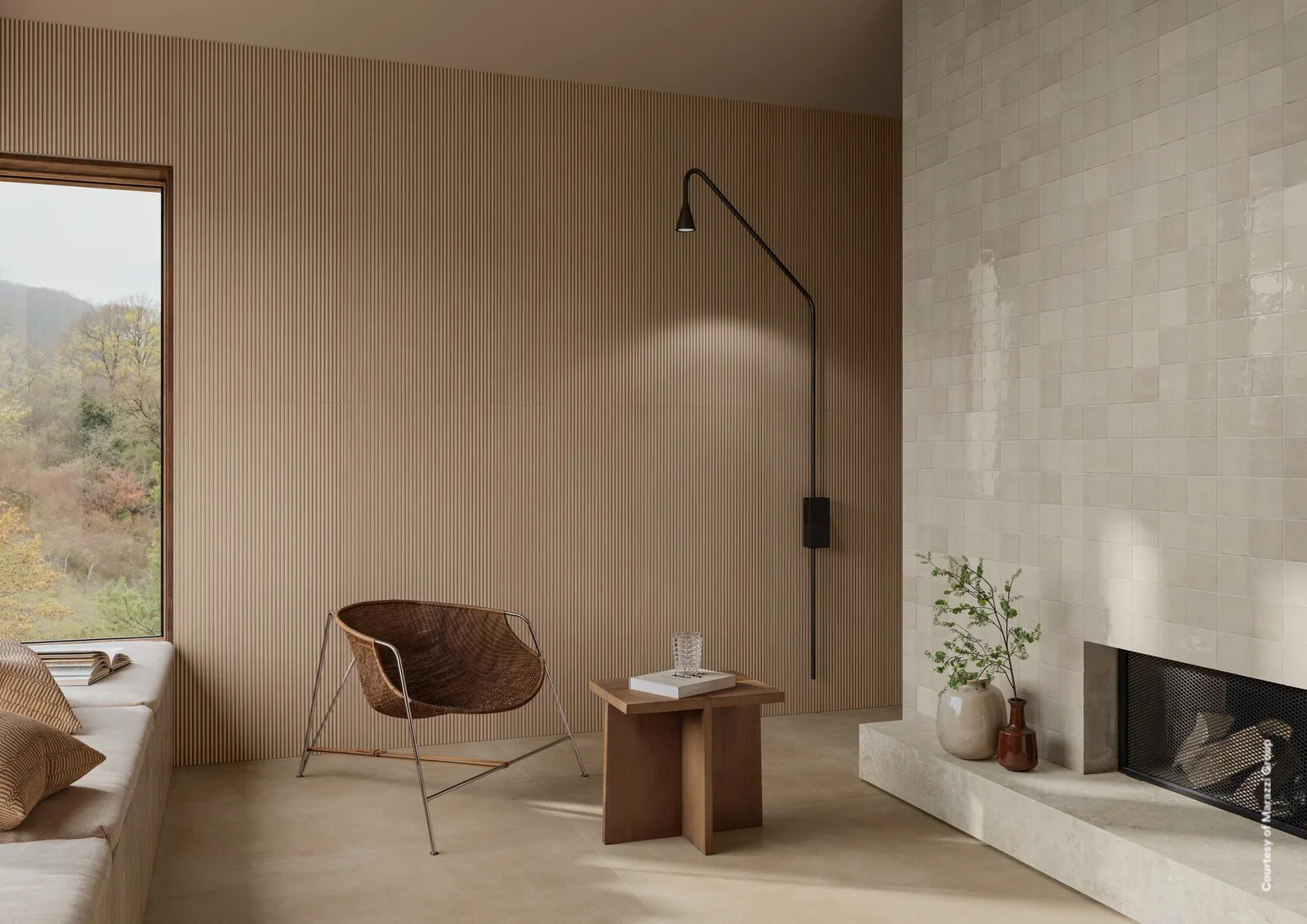 Wohnzimmer mit Kamin und Sessel, Wand aus fein gerillten Wandfliesen in heller Eichenholzoptik neben dem Fenster