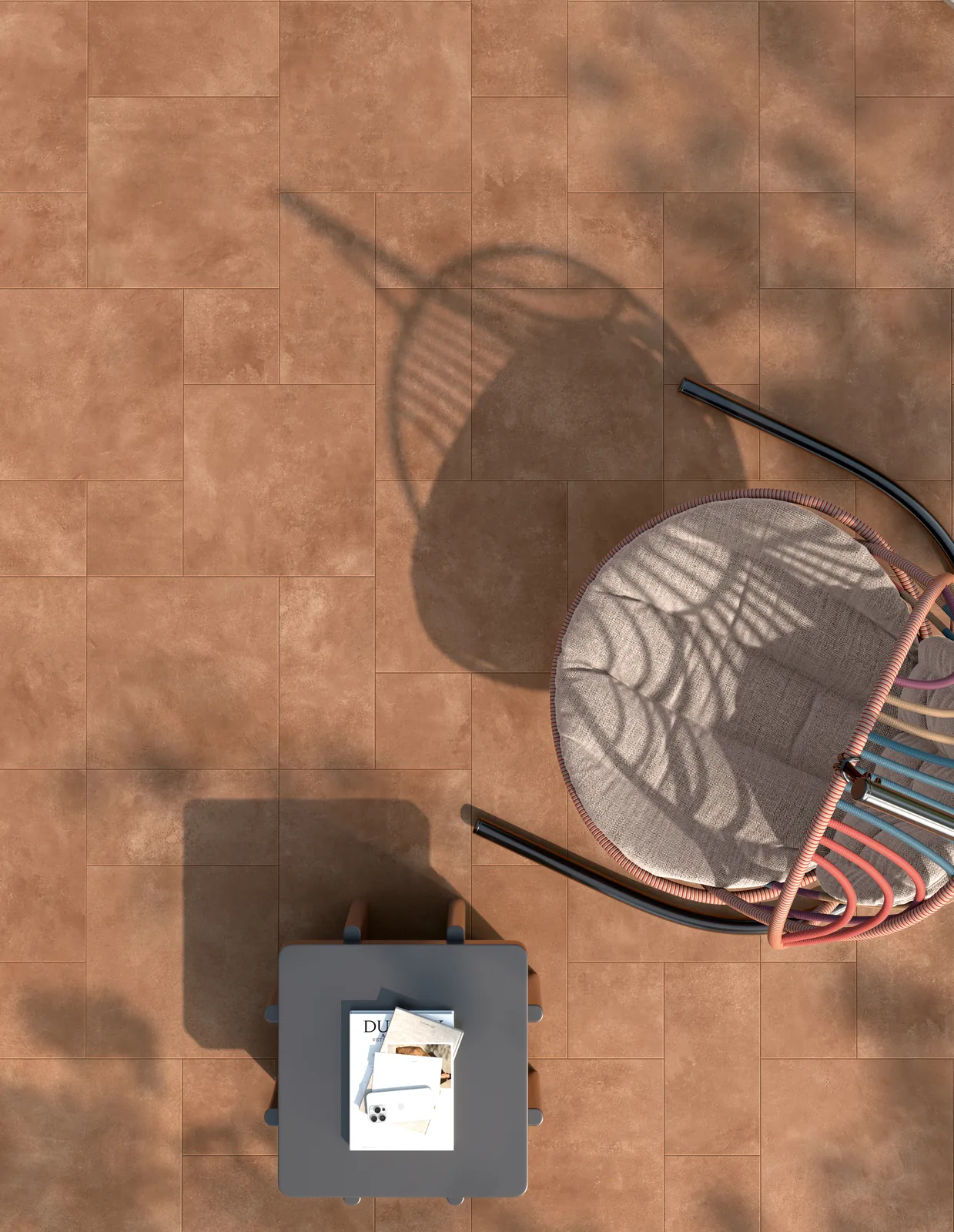 Draufsicht auf orangebraune rutschhemmende Terrassenfliesen mit Gartenstuhl, Hocker und Schattenwurf