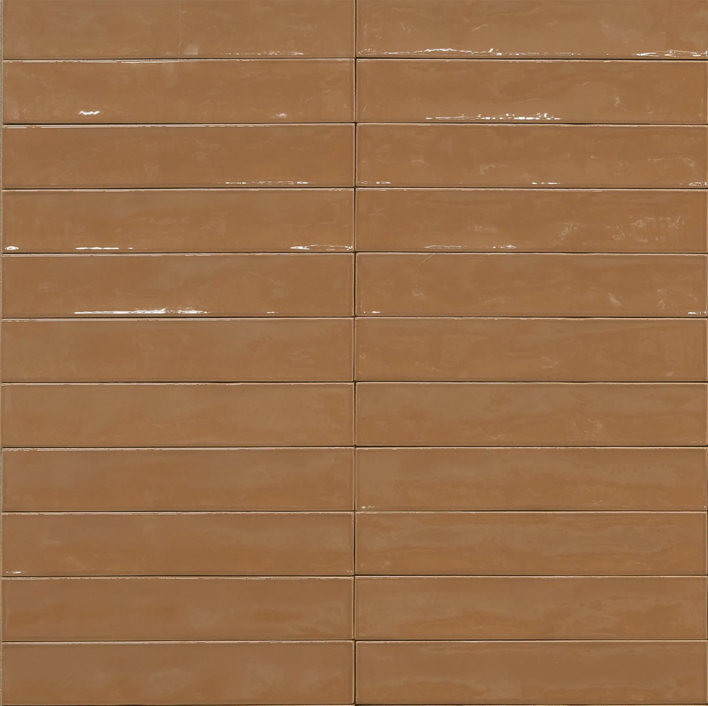 Glänzende Wandfliese 5,3x30 cm in warmem Karamellbraun, schmale Riemchen mit leicht welliger Glasur und unregelmäßigen Kanten