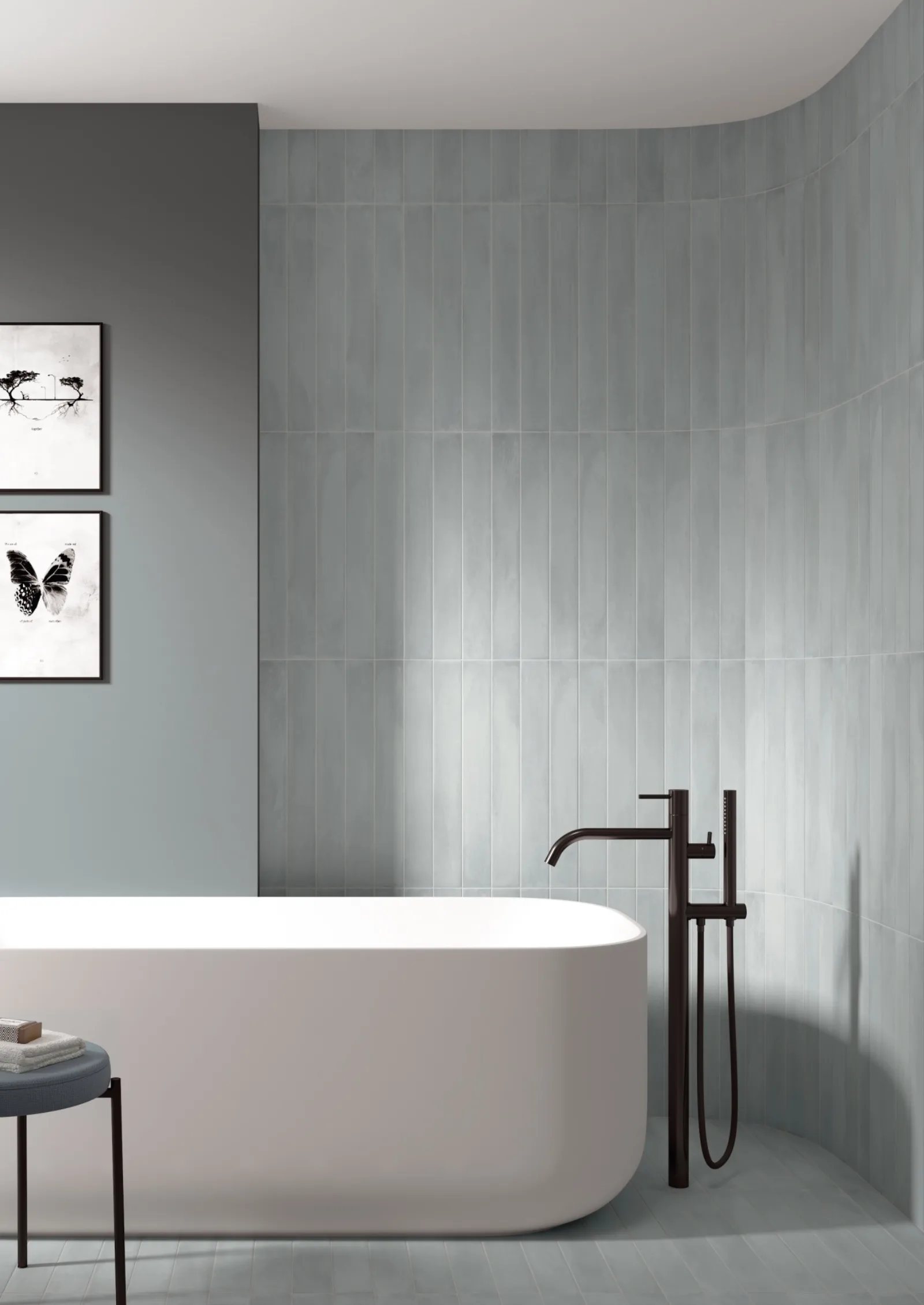 Bad mit graublauer Riemchenwand aus Stonella Atlantic und freistehender weißer Badewanne