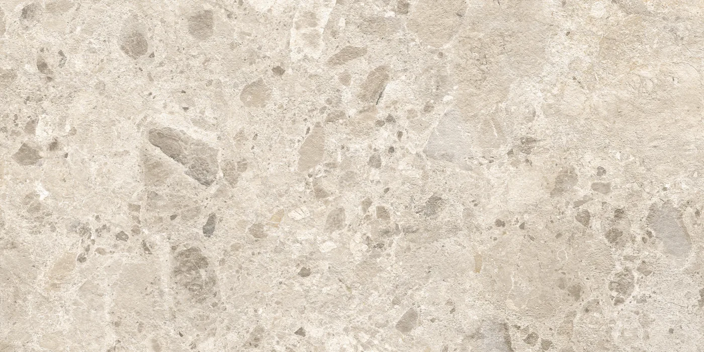 Beige Fliese 60×120 cm in Terrazzo-Optik mit grauen und hellen Steinsplittern unterschiedlicher Größe auf heller Fläche.