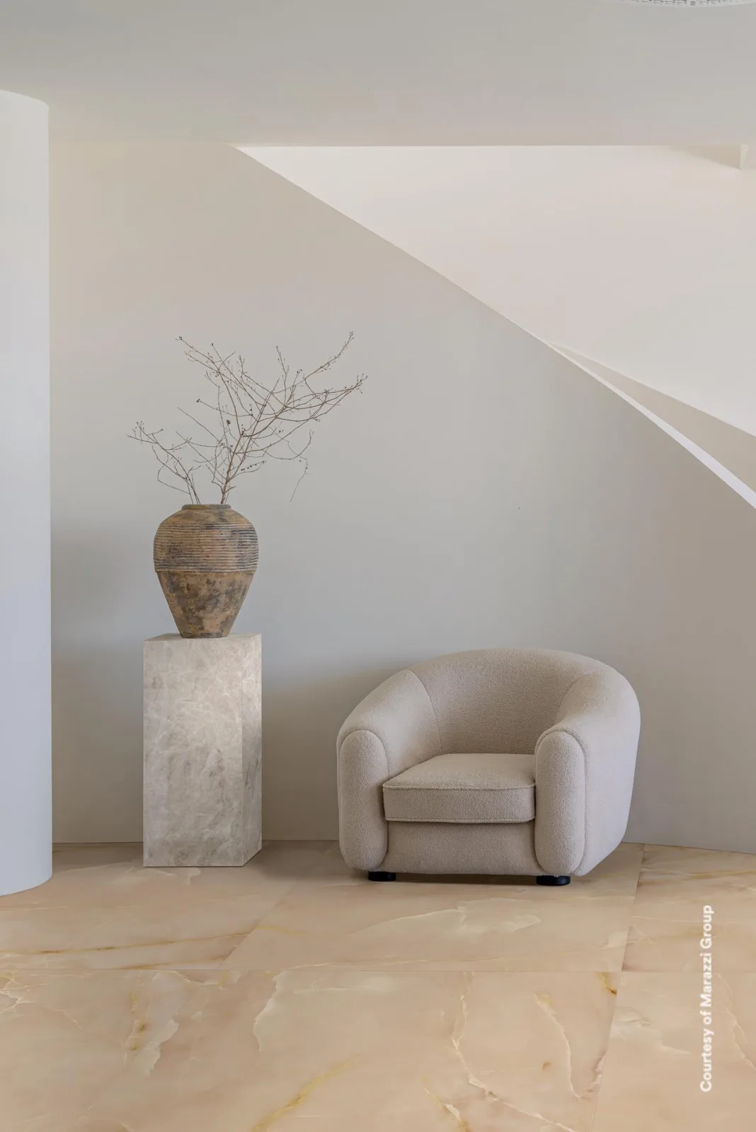 Heller Raum mit Sessel und Vase auf Podest, gefliest mit Marazzi Allmarble Onice Beige in 120x120cm.